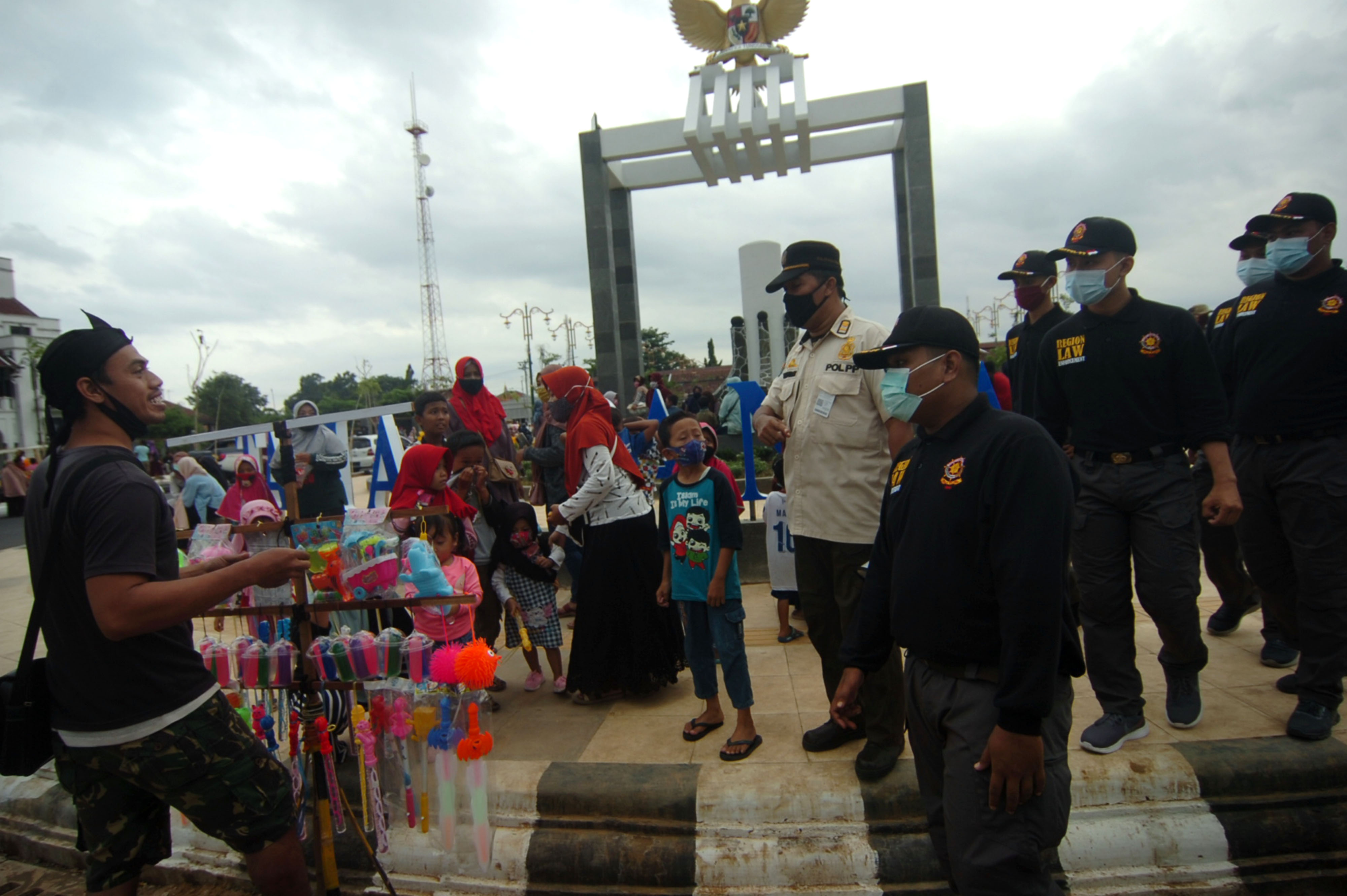 Personel Satpol PP menegur warga yang tidak memakai masker saat operasi yustisi protokol kesehatan di Taman Pancasila, Tegal, Jawa Tengah.