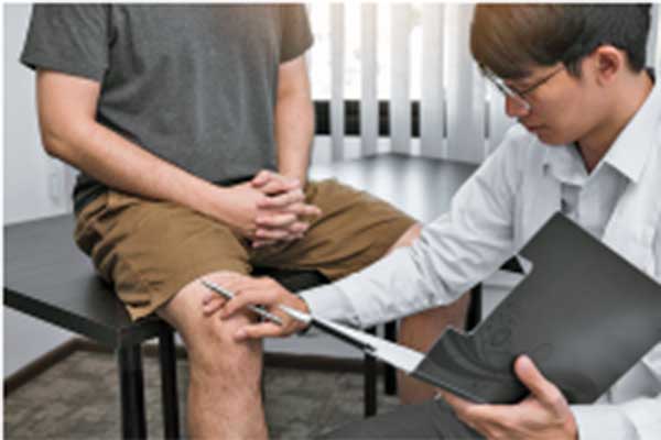 Seorang dokter sedang memeriksa kaki pasien