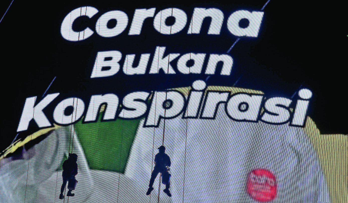 TAA T PROTOKOL KESEHATAN: Pekerja membersihkan layar iklan pesan layanan masyarakat terkait dengan penanganan covid-19 di Jakarta,  