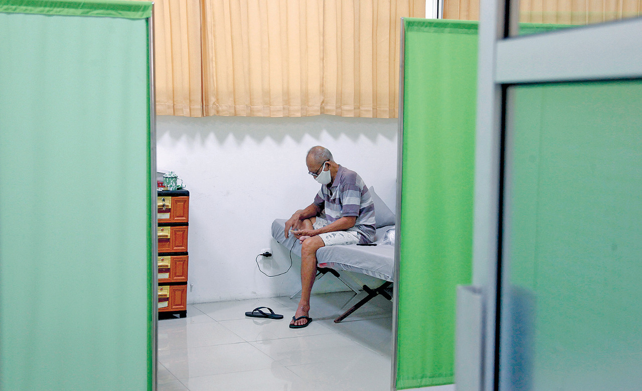 Pemudik menggunakan telepon seluler saat menjalani karantina guna mencegah penyebaran covid-19 di Solo Technopark, Jebres, Surakarta.