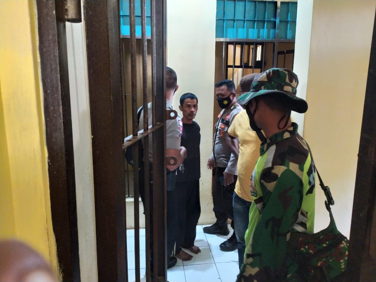 Jois Togilang, 41, pembunuh (kaos hitam) dimasukkan ke sel Mapolres Lembata seusai menyerahkan diri ke pejabat desa, Minggu (27/12/2020)