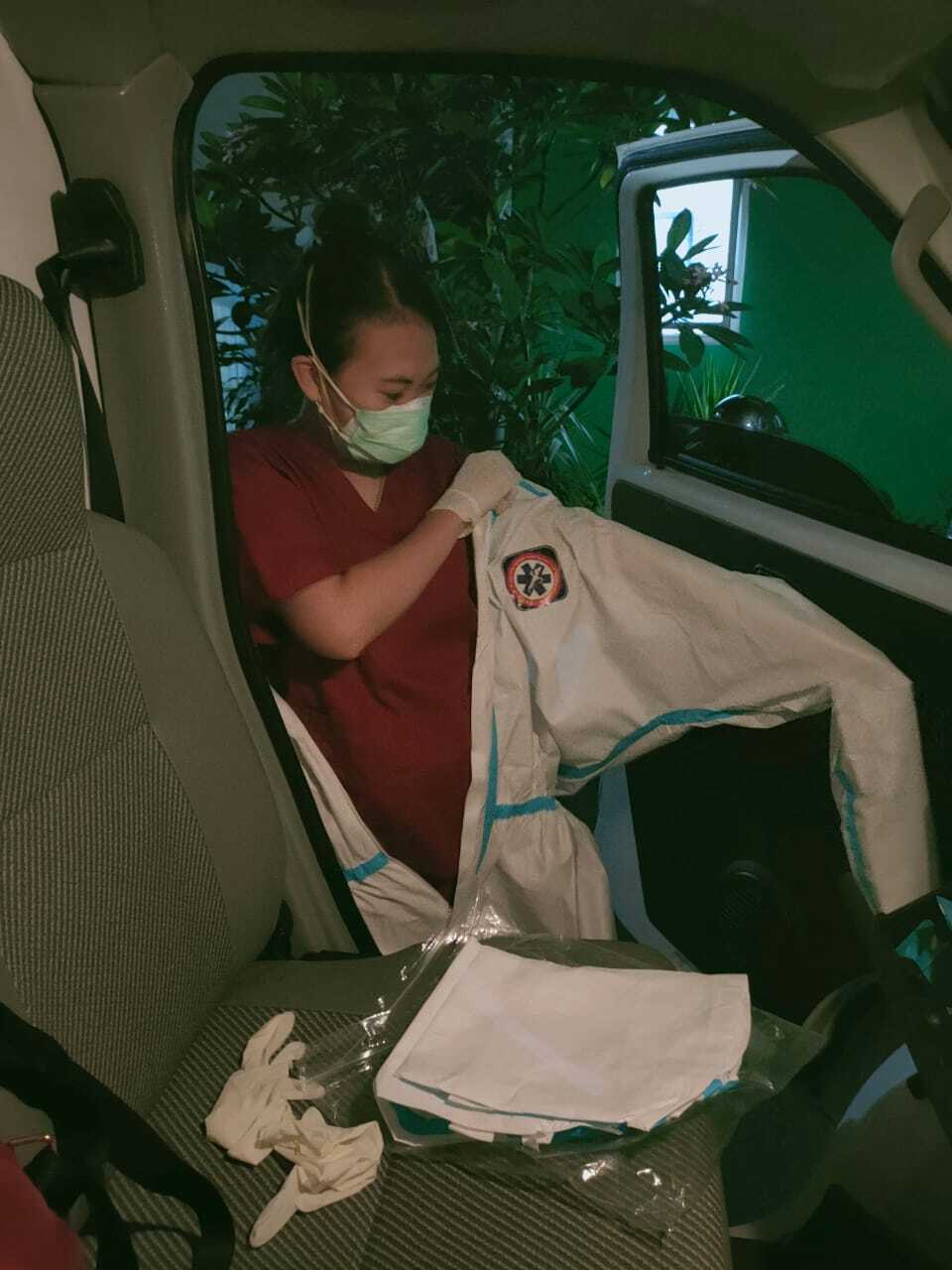 Ika Dewi Maharani, relawan pengemudi ambulans mengenakan hazmat sebelum bertugas menjemput pasien dan mengantarnya ke rumah sakit rujukan.