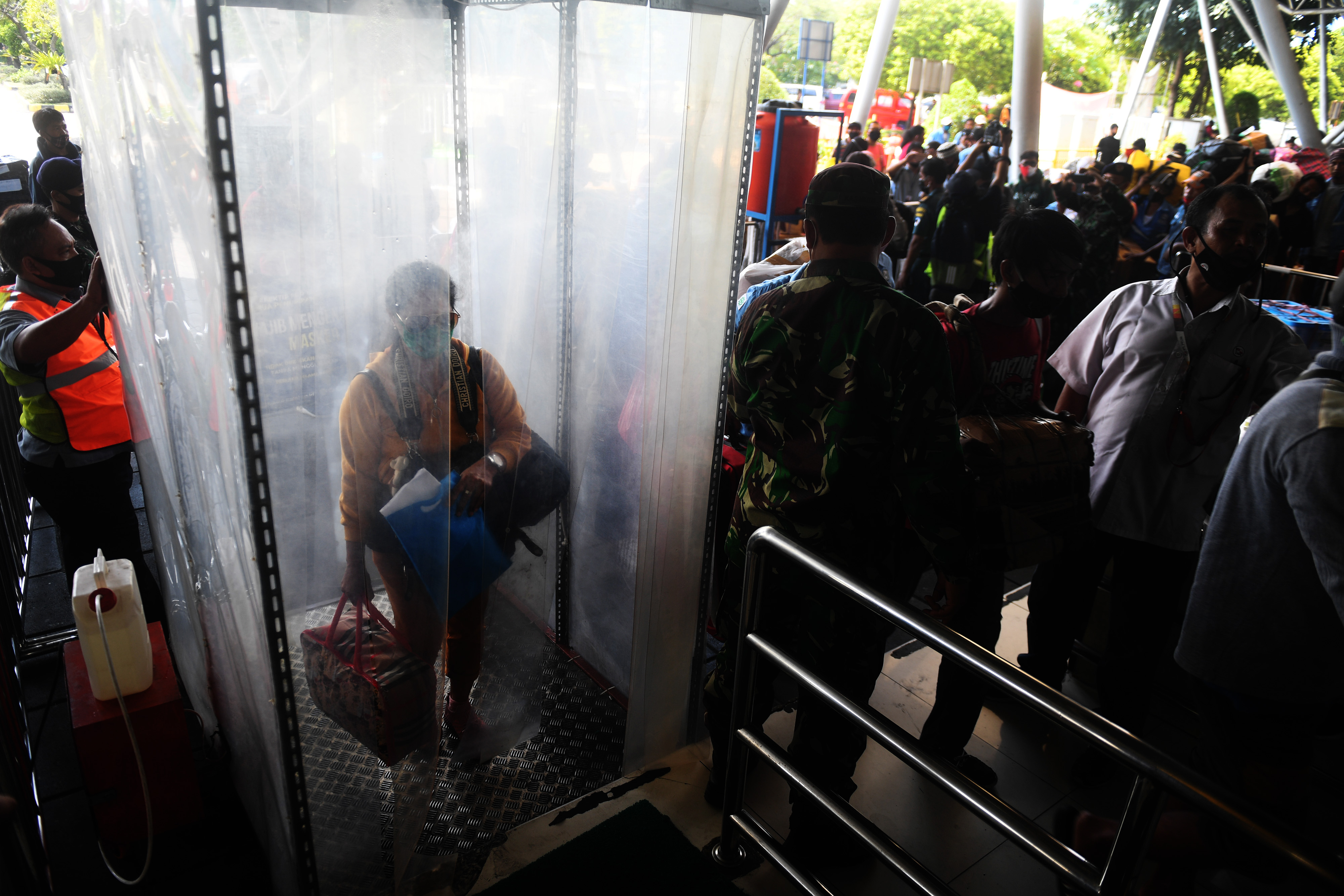 PROTOKOL KESEHATAN ANGKUTAN LAUT: Penumpang melewati bilik disinfektan sebelum menaiki KM Dorolonda di Terminal Penumpang Tanjung Priok.