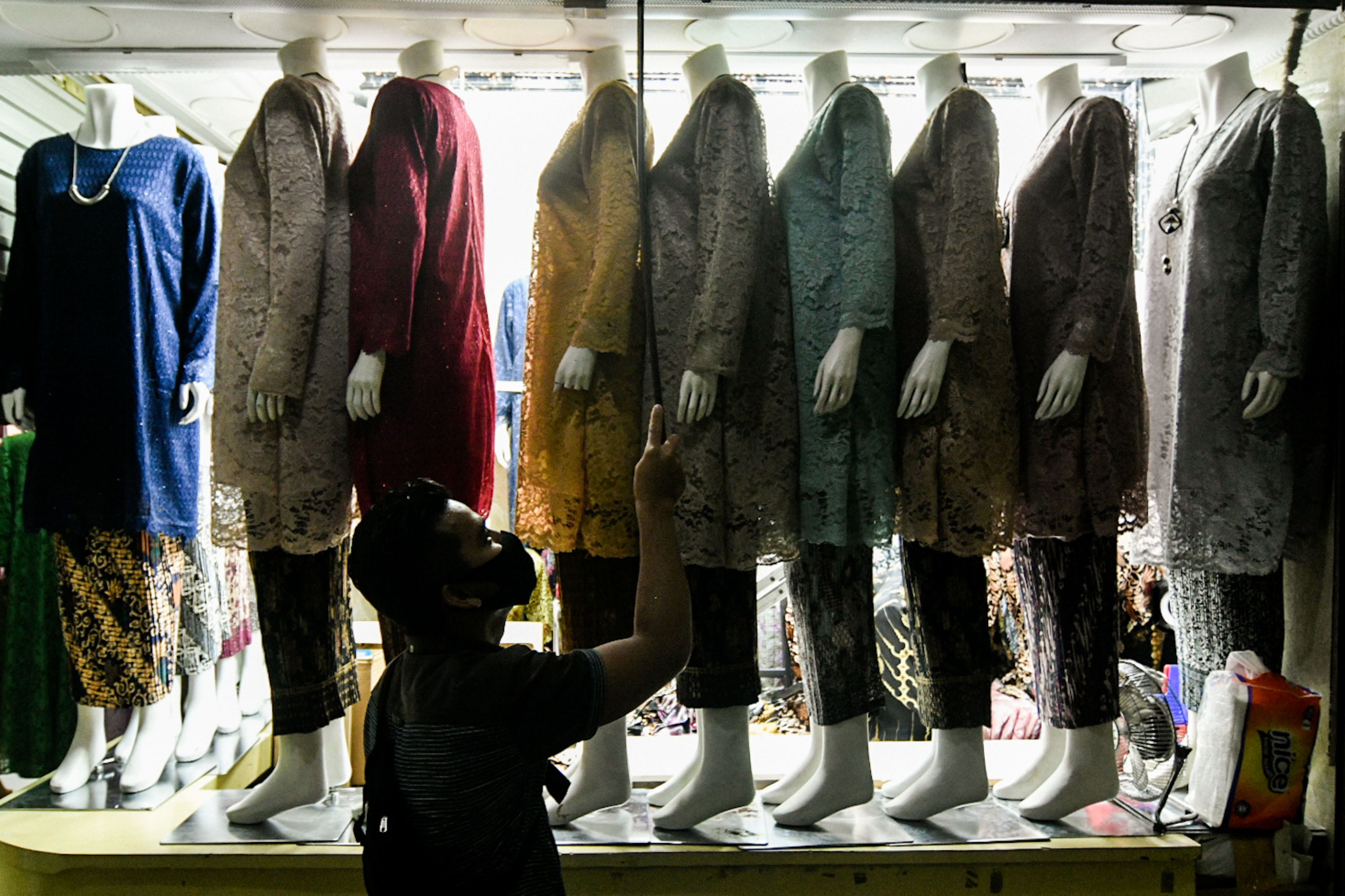 Pedagang menata tokonya yang berlokasi di Pasar Tanah Abang, Jakarta.