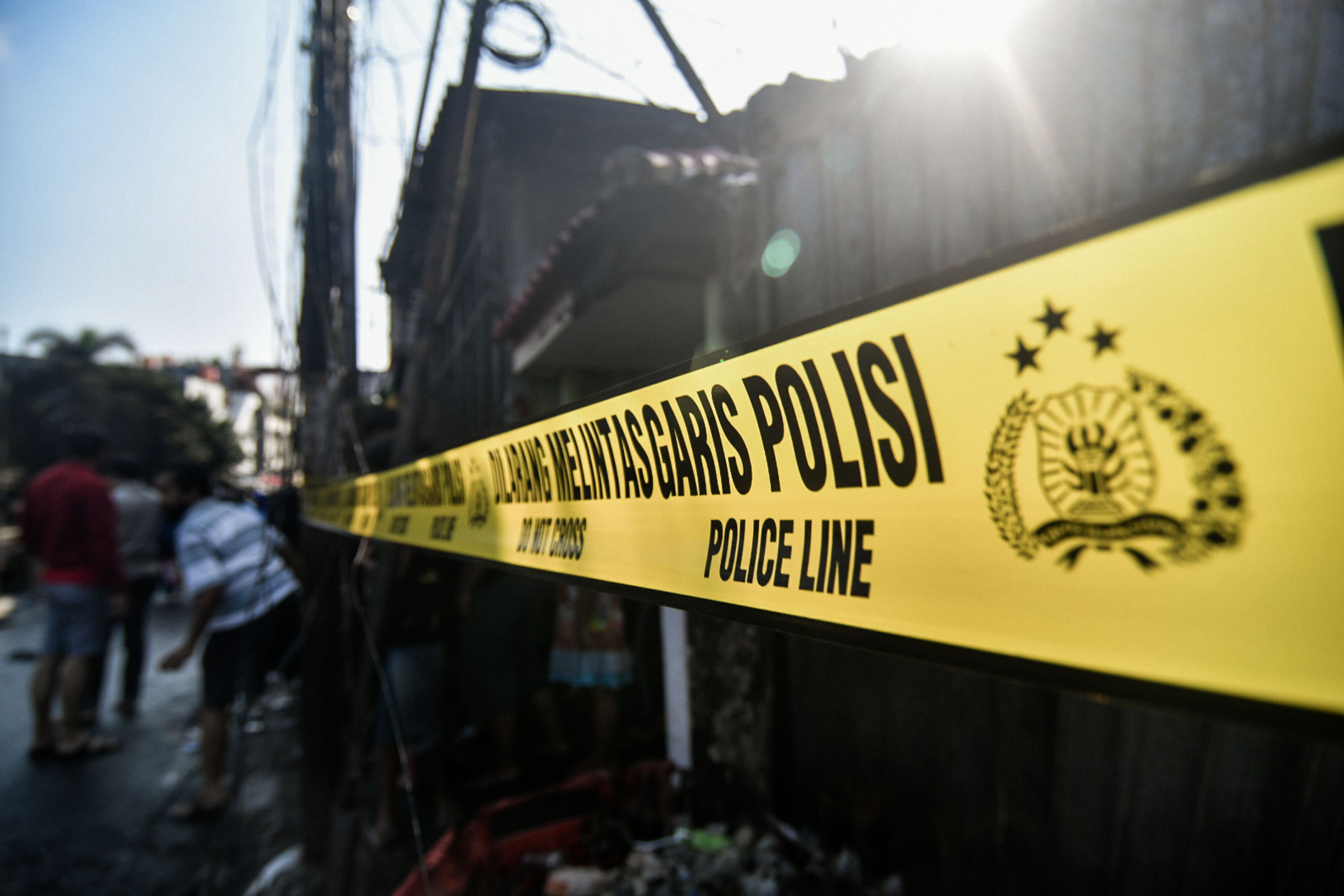 Ilustrasi pemasangan garis polisi di tempat kejadian perkara. 