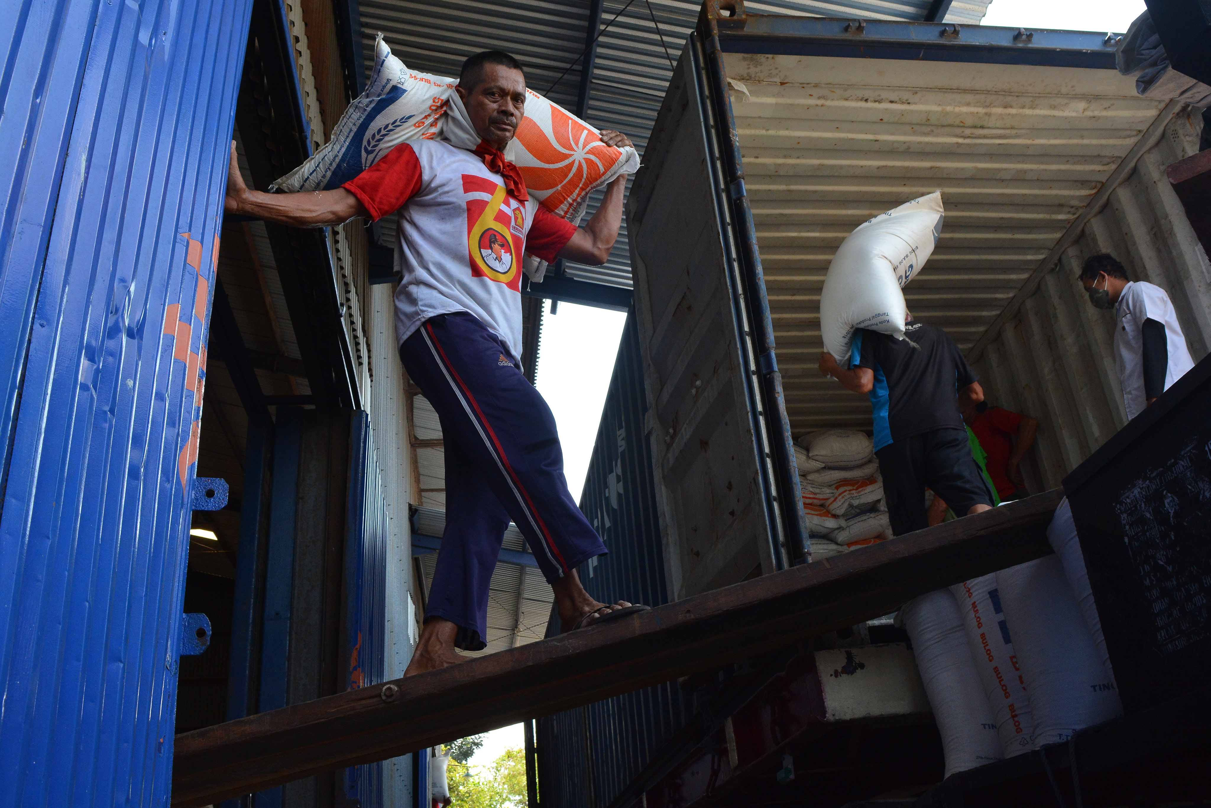 Pekerja mengangkat beras bansos di gudang Tunggorono 2, Kabupaten Jombang, Jawa Timur, Rabu (16/9)