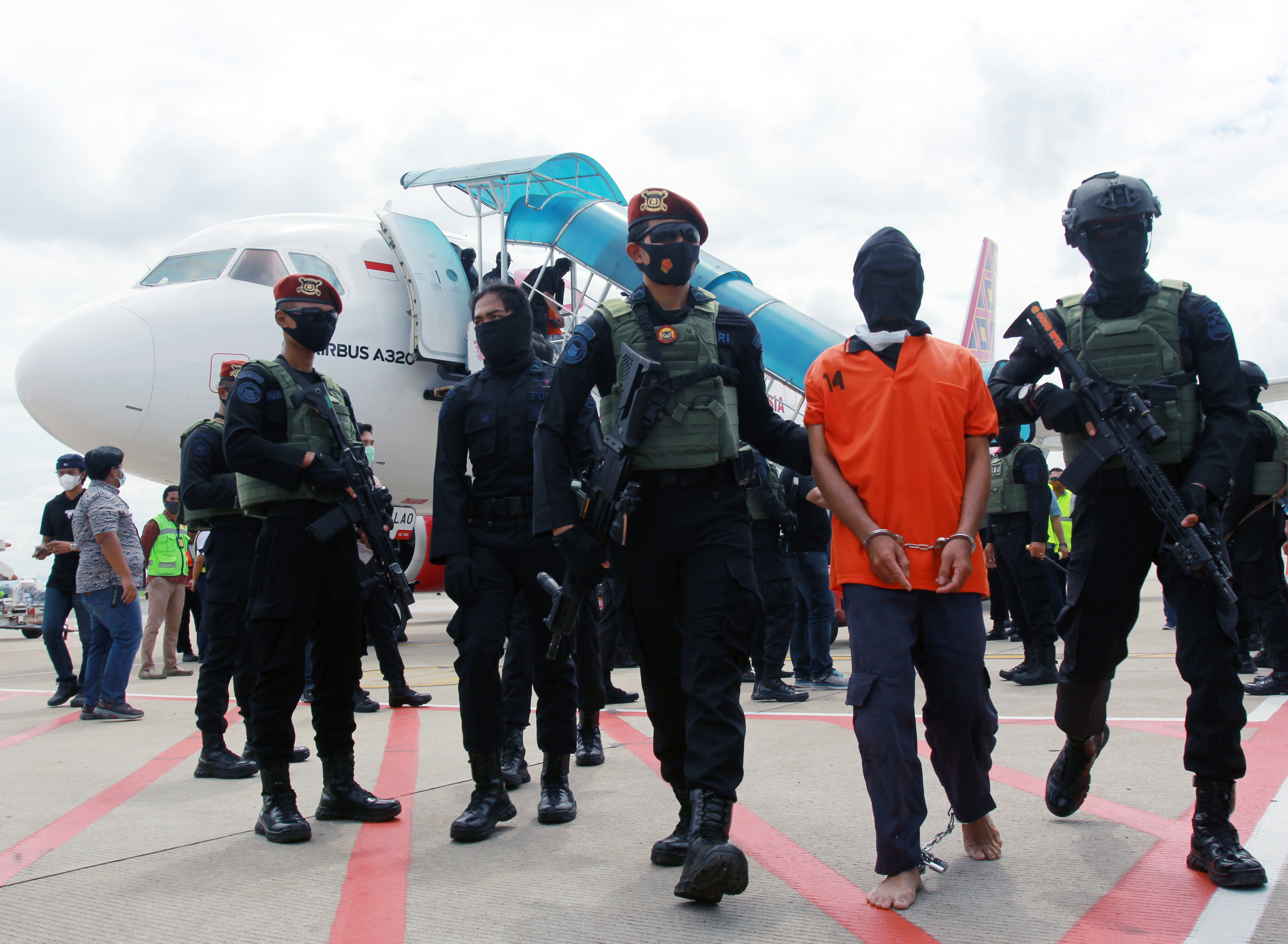 Petugas Densus 88 membawa terduga teroris Taufik Bulaga alias Upik Lawanga dari Lampung setibanya di Bandara Soekarno Hatta, Rabu (16/12).