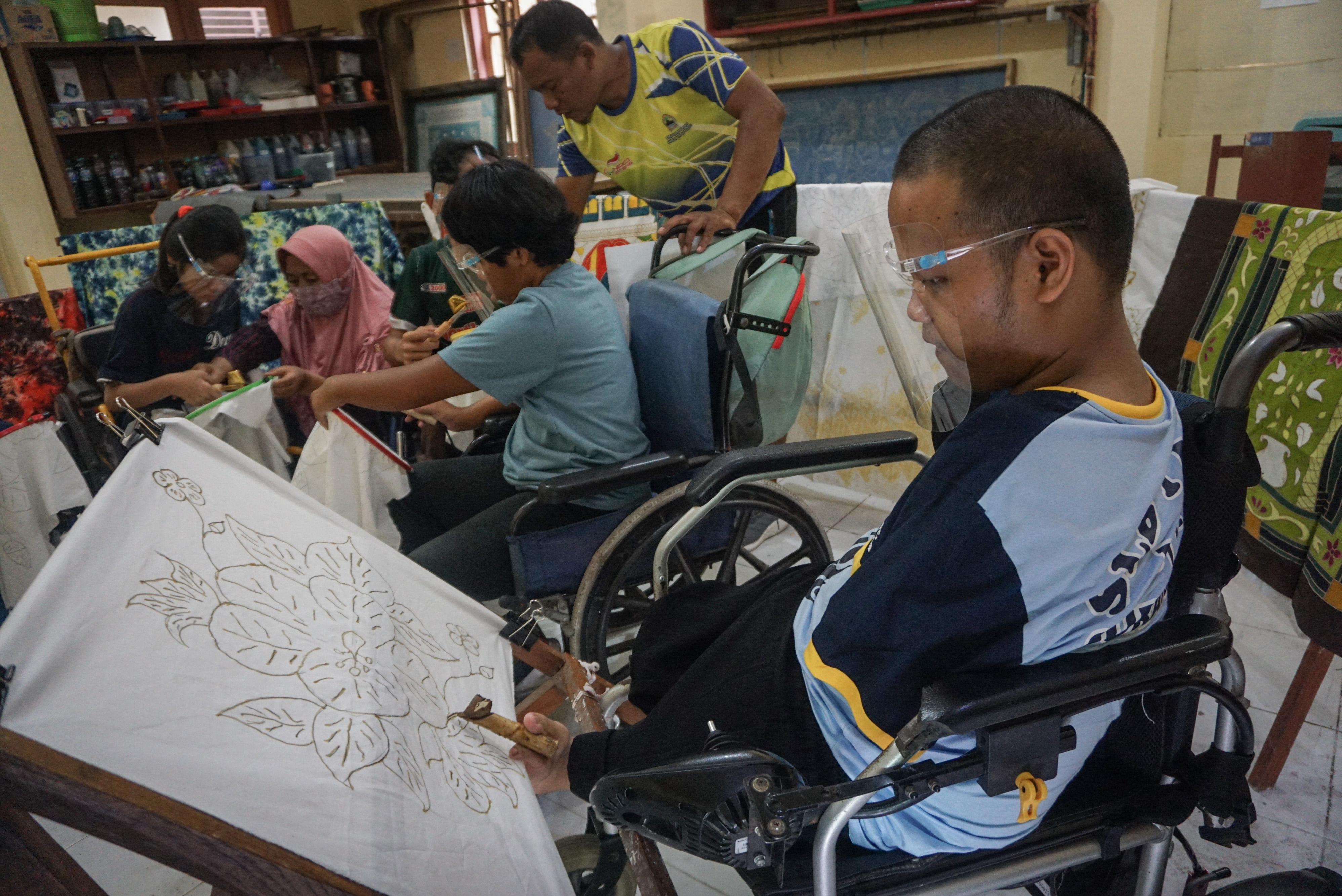 Guru membimbing siswa penyandang disabilitas belajar membatik di YPAC Solo, Jawa Tengah, Rabu (2/11).