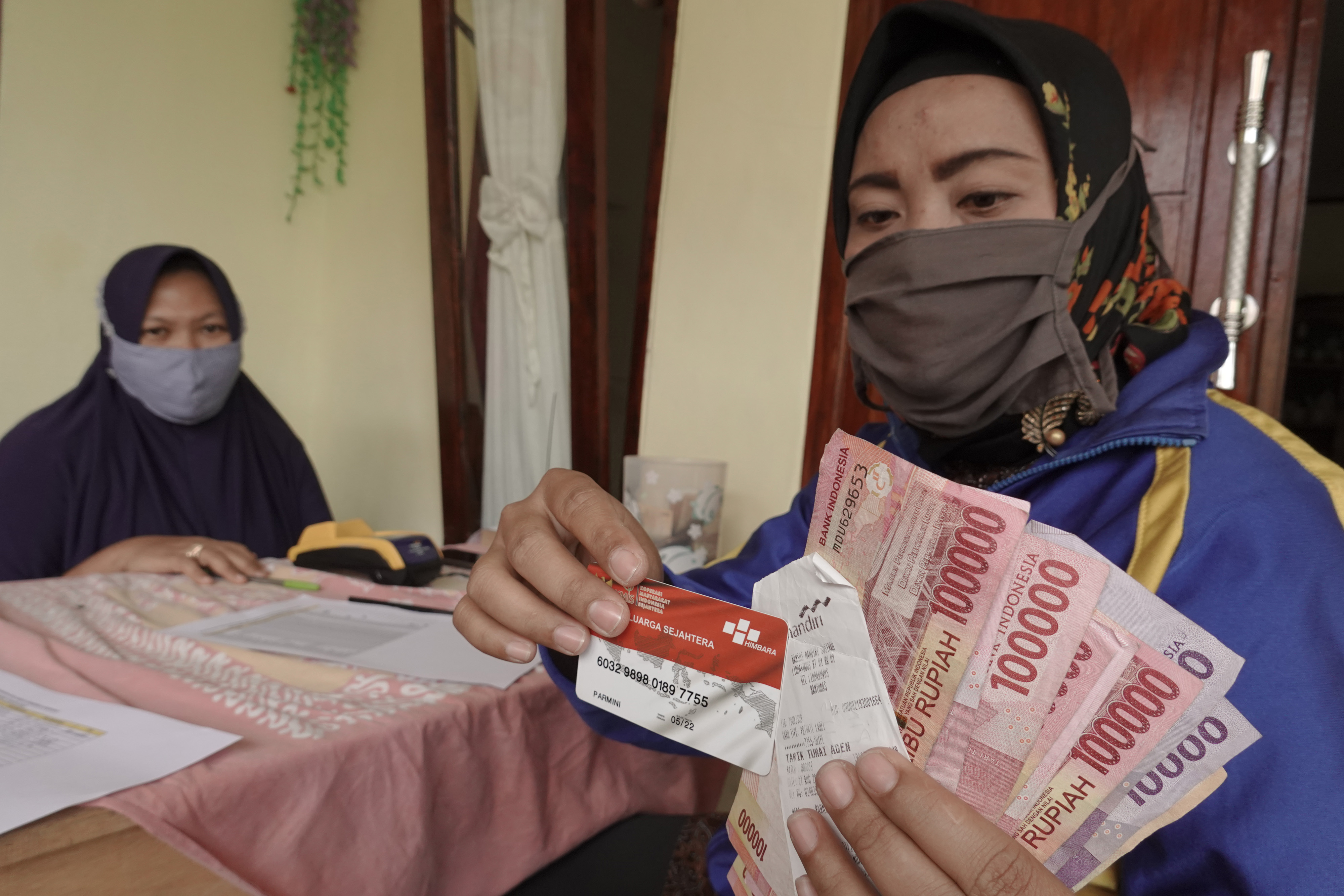 Warga menunjukan Kartu Keluarga Sejahtera yang digunakan untuk menarik dana bantuan sosial PKH di Desa Limpakuwus, Sumbang, Banyumas, Jateng