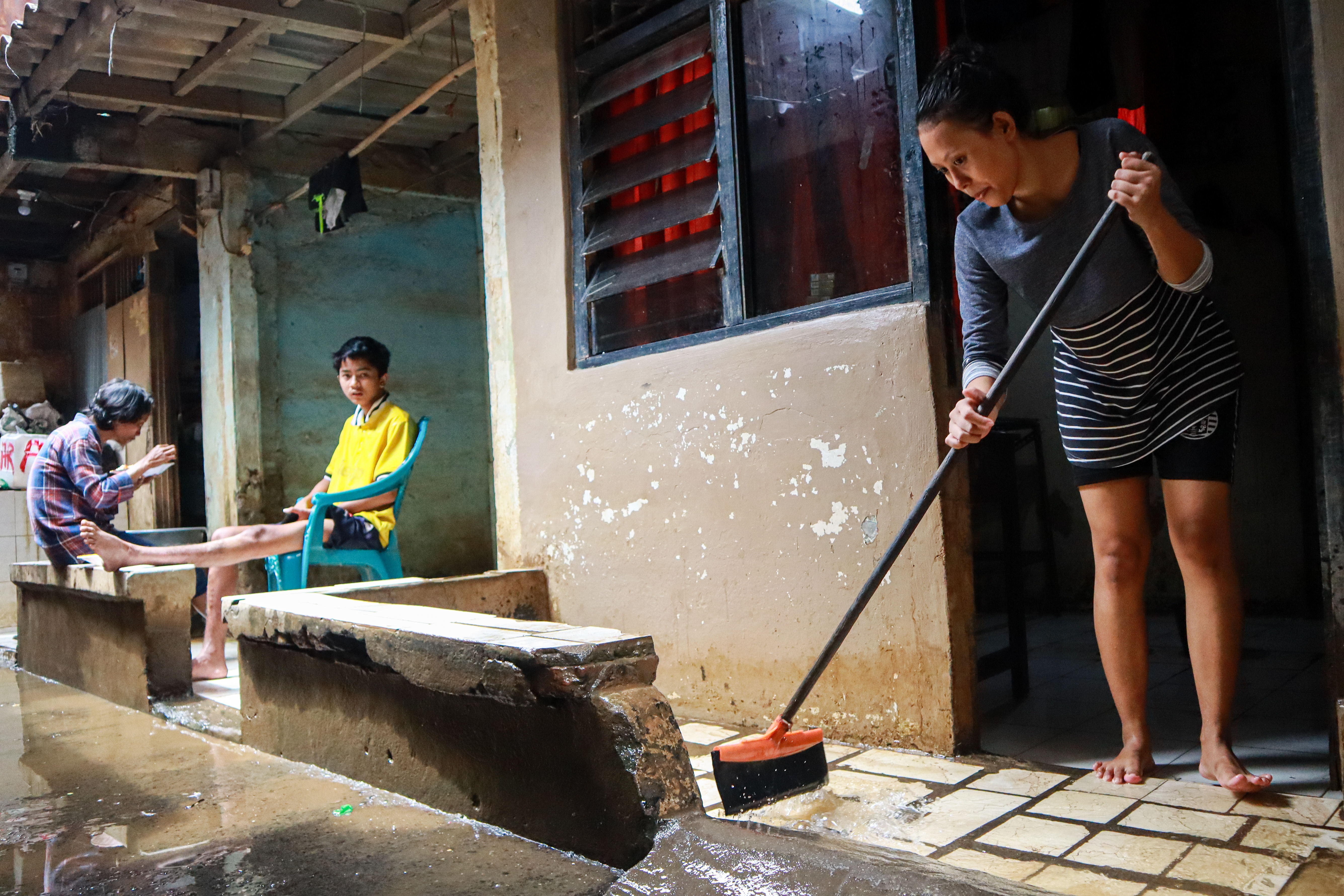 Warga membersihkan sisa lumpur akibat banjir di kawasan Kebon Pala, Jatinegara, Jakarta, Senin (7/12/2020). 