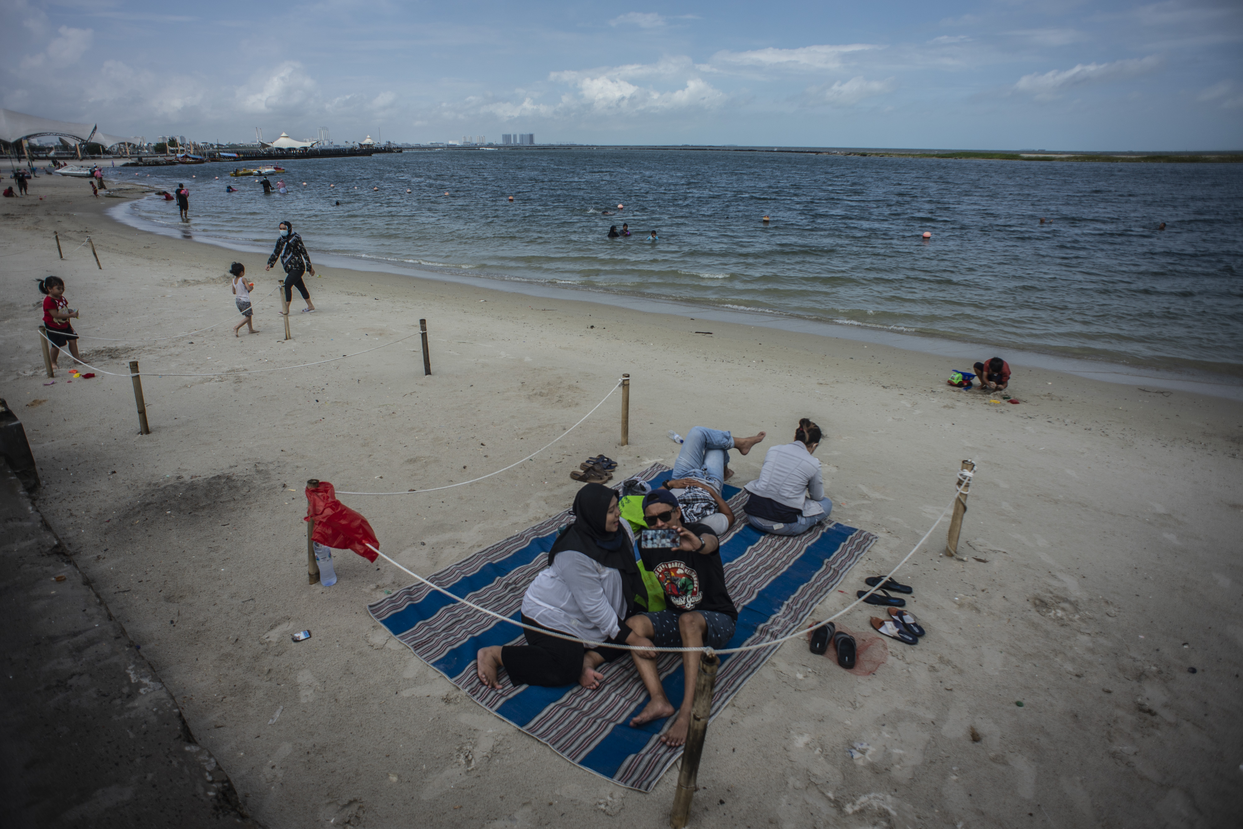  Wisatawan berswafoto di Pantai Lagoon, Taman Impian Jaya Ancol, Jakarta, Rabu (9/12/2020).