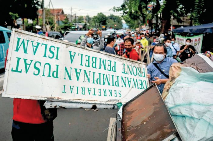 Petugas mencopot papan nama Front Pembela Islam (FPI) di Petamburan, Tanah Abang, Jakarta Pusat, Rabu (30/12/2020).