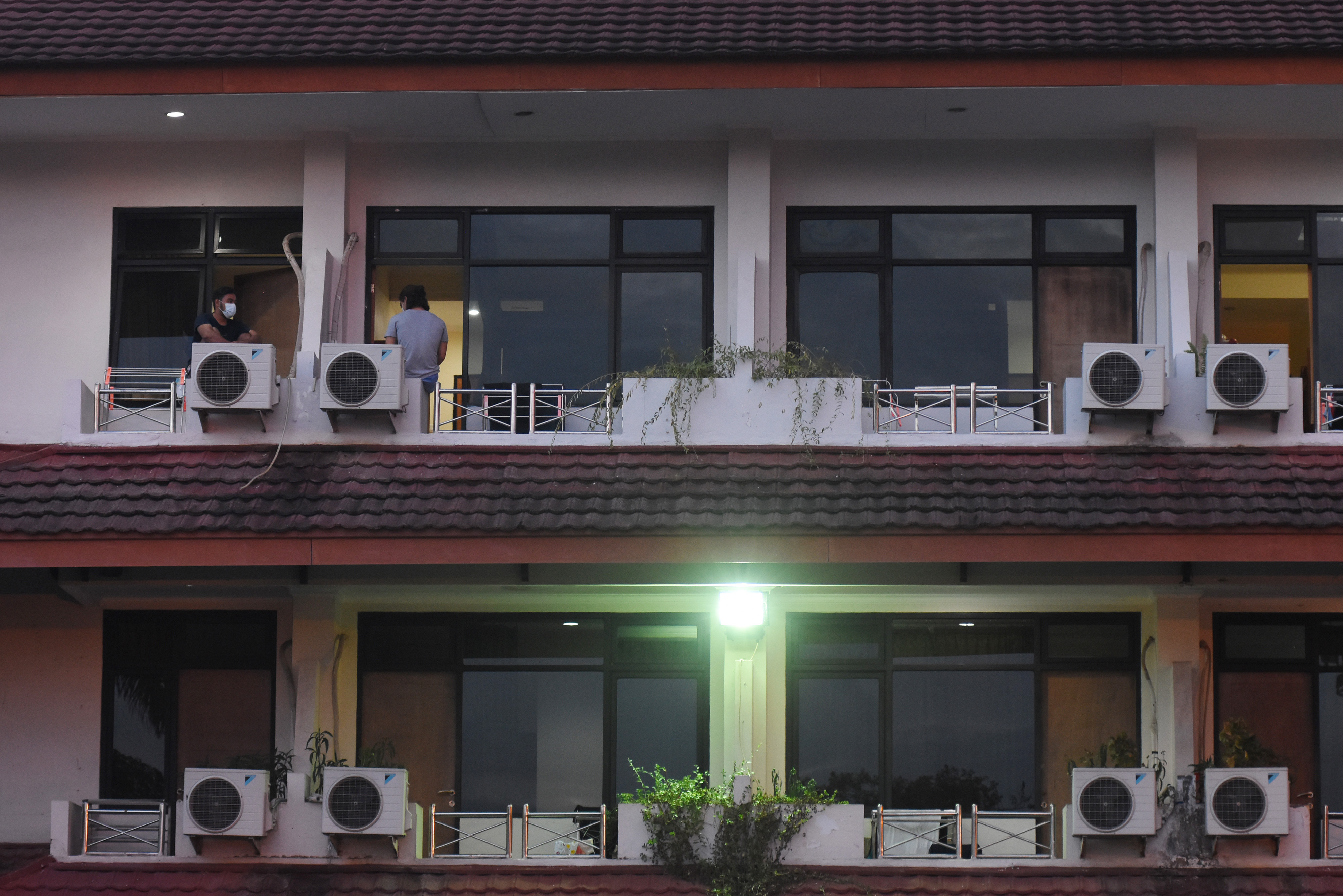 Dua pasien OTG COVID-19 berbincang di balkon kamar isolasinya di Graha Wisata Ragunan, Jakarta, Sabtu (26/12).