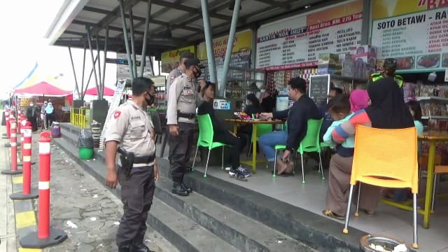 Petugas menegur warga di rest area Km 175 Tol Pejagan-Pemalang yang berkerumun dan tidak memakai masker, Kamis (24/12/2020)