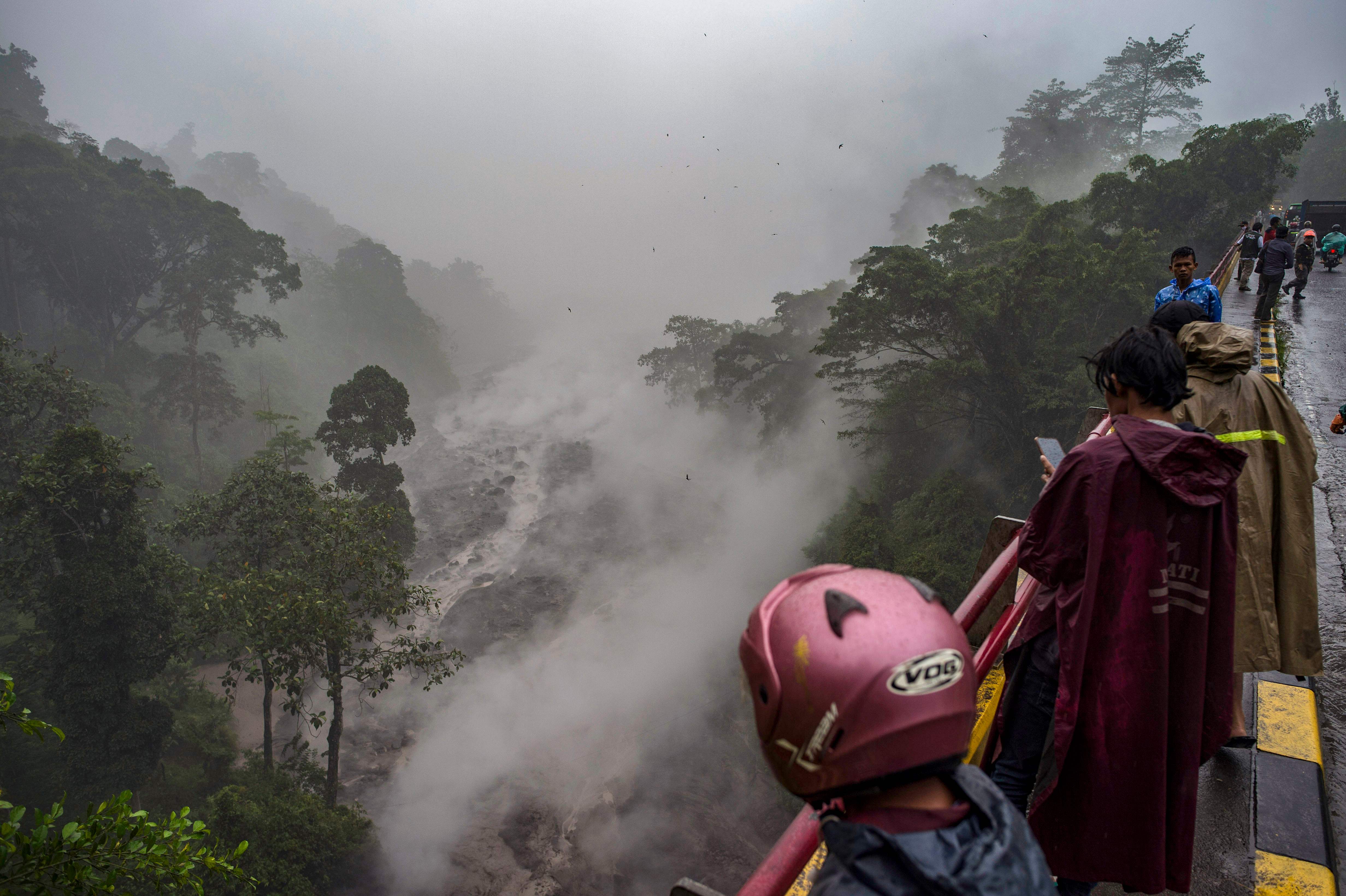 Warga melihat banjir lahar dingin di sebuah sungai di Lumajangm Jawa Timur, Kamis (3/12) setelah letusan Gunung Semeru.