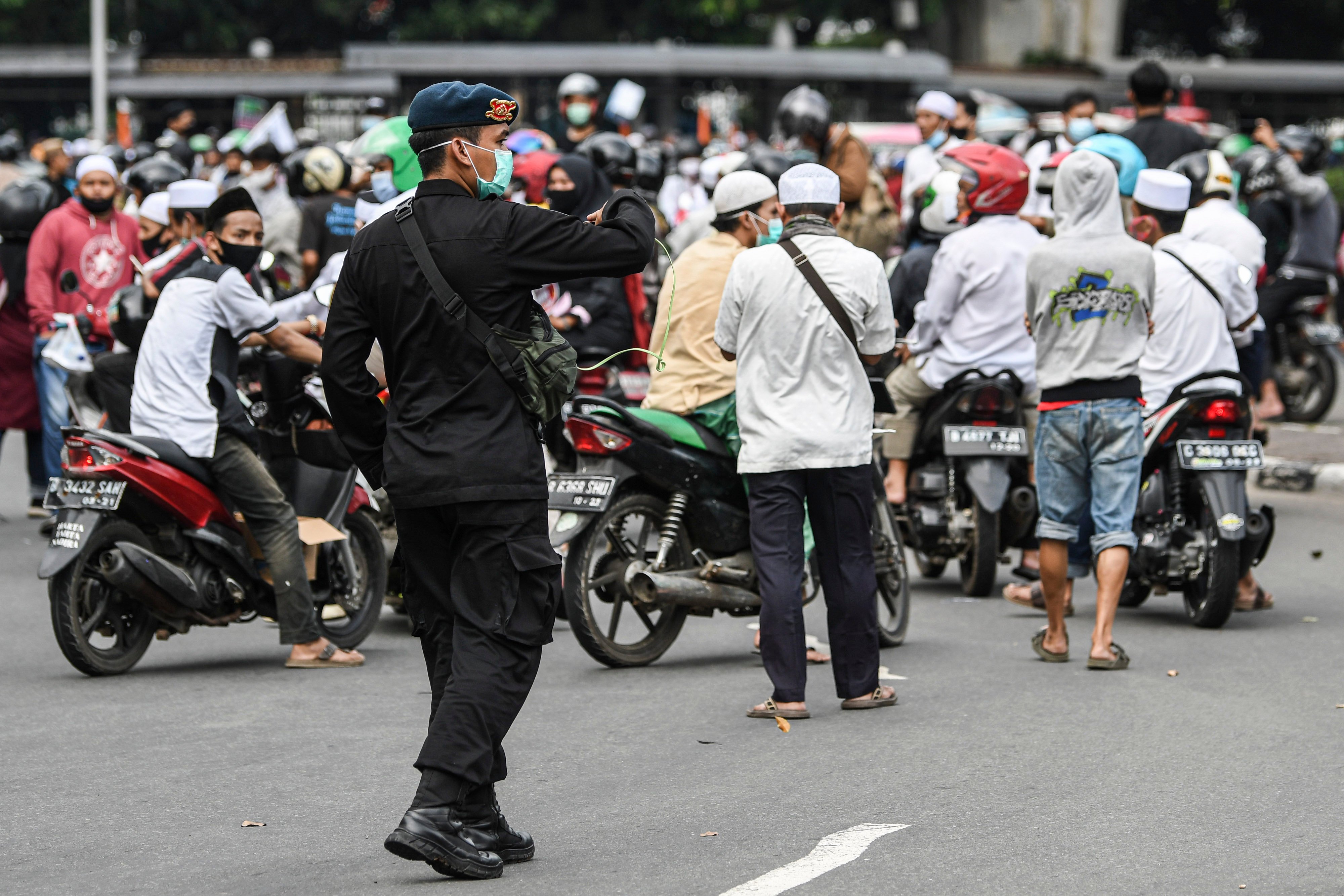 Personel Brimob Polri menghalau massa aksi protes 1812 di wilayah Jakarta.