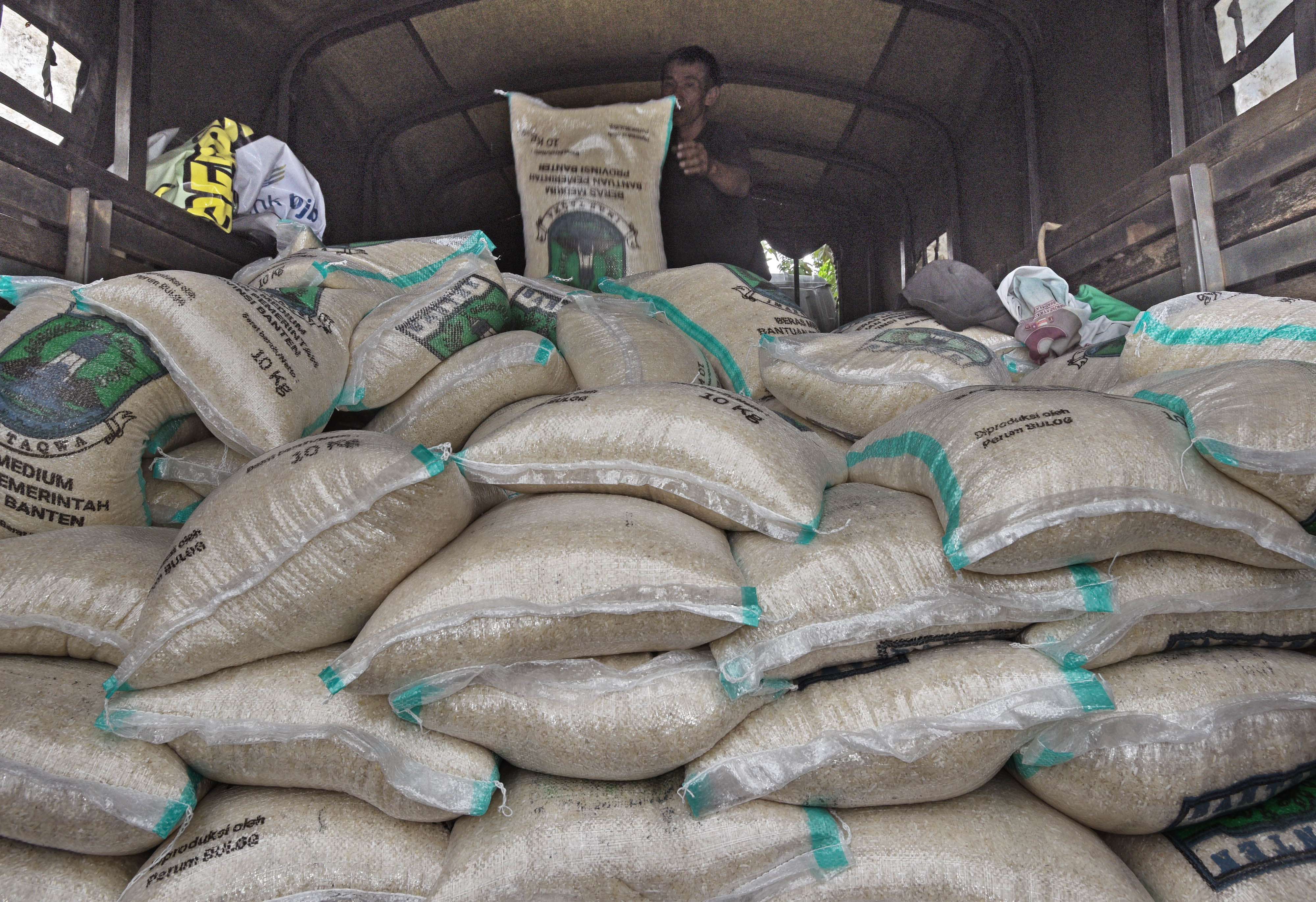  Pekerja mengangkat beras bantuan nontunai untuk warga terdampak covid-19.