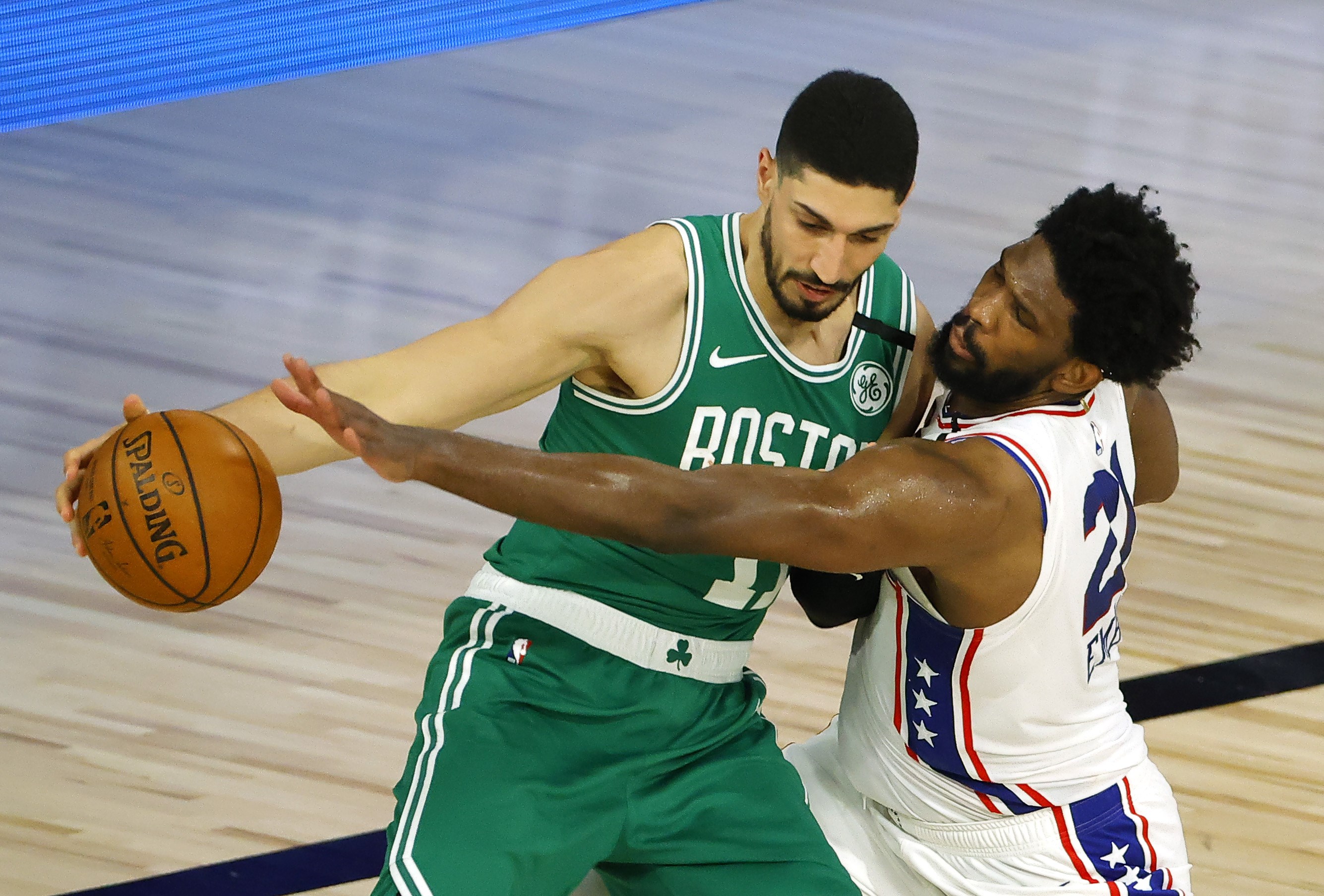 Aksi Joel Embiid (kanan) dari  Philadelphia 76ers berusaha merebut bola dari tangan Enes Kanter, pemain Boston Celtics. 