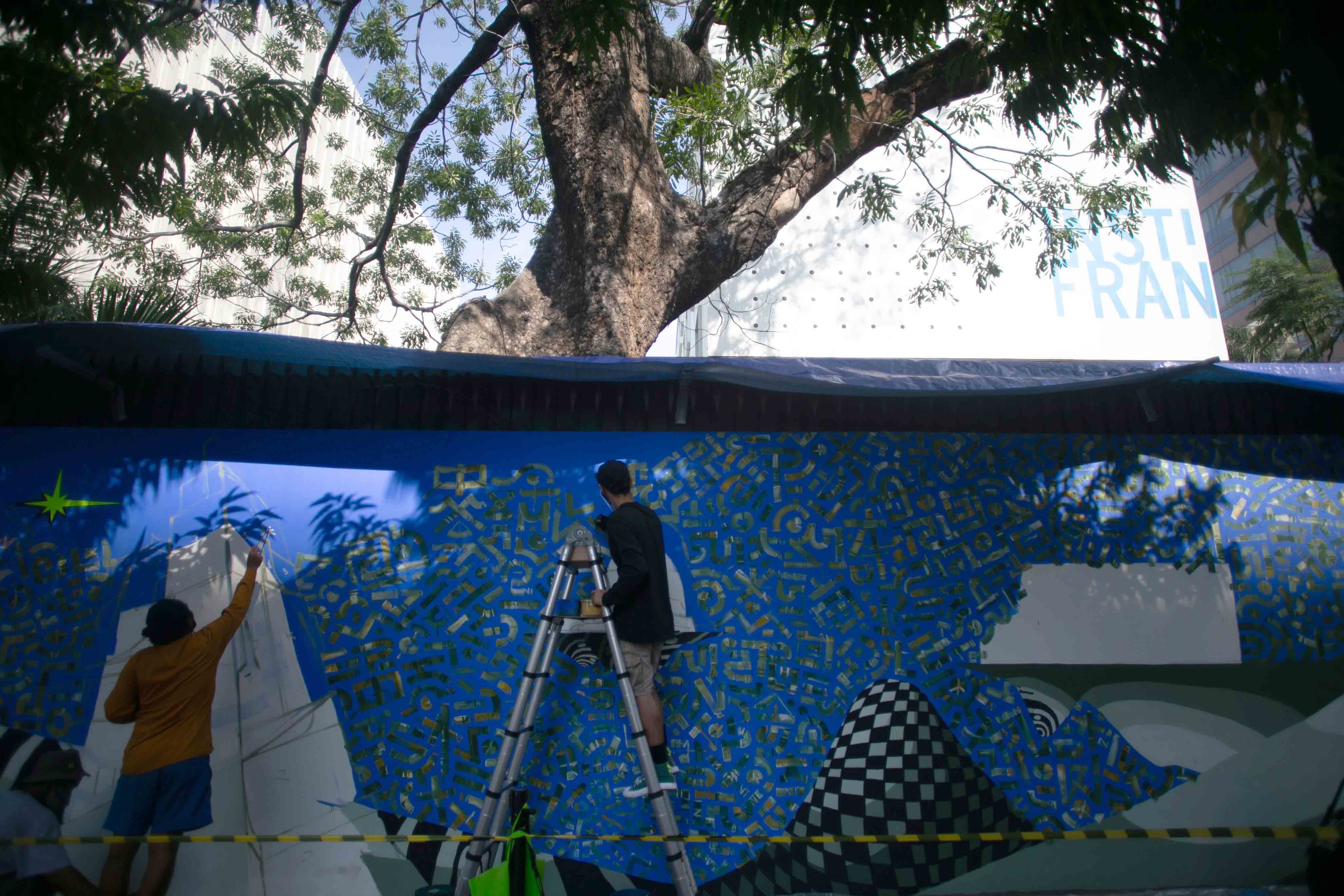 Seniman Olderplus dan Blesmokies menggambar mural dalam kolaborasi dengan Converse