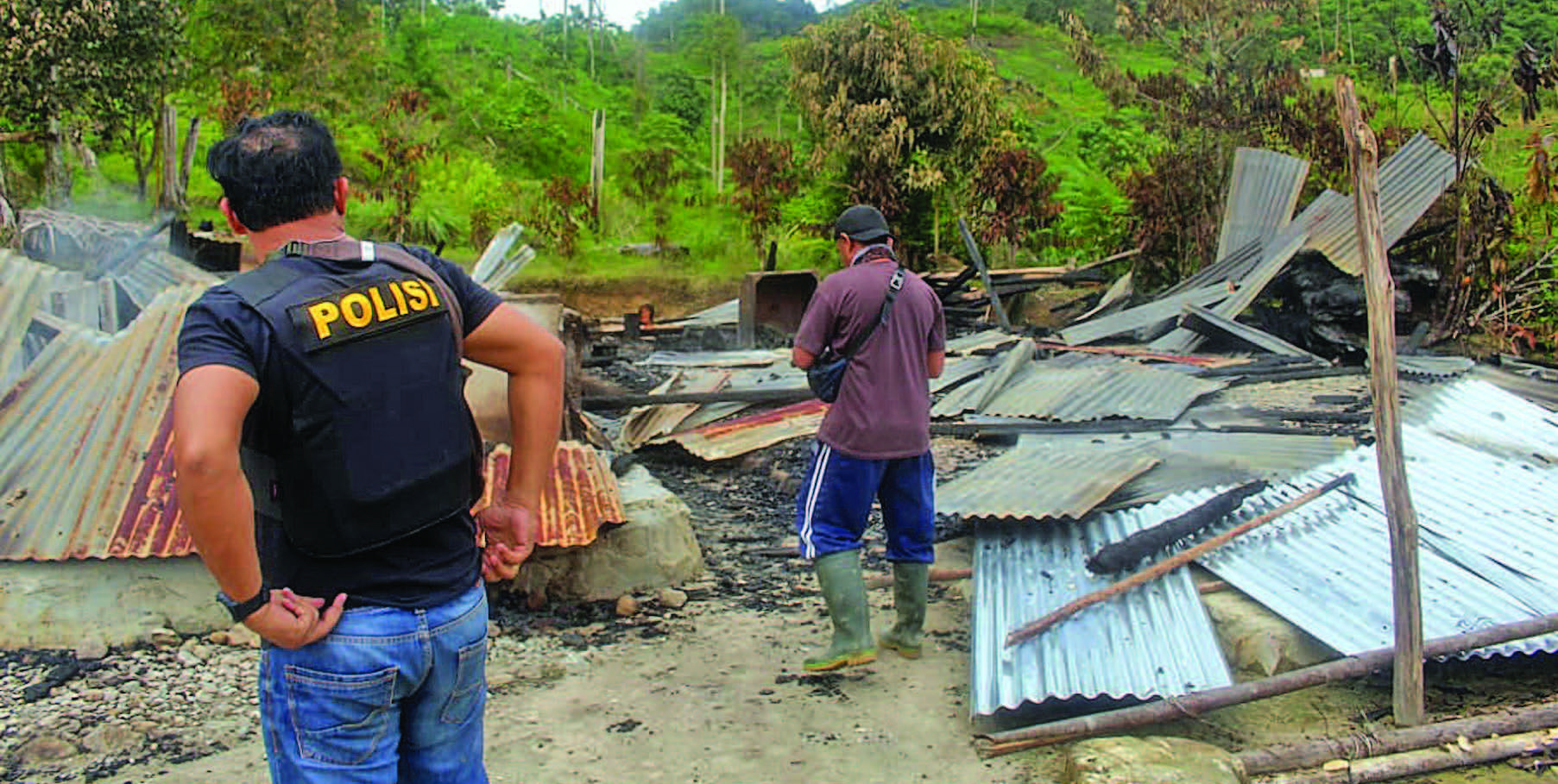 SERANGAN KELOMPOK TERORIS MIT DI SIGI: Polisi memeriksa bangunan yang dibakar dalam serangan yang diduga dilakukan kelompok teroris  