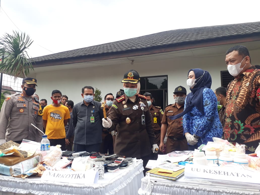 Kepala Kejari Karawang Rohayatie melakukan simbolis pemusnahan barang bukti dengan memukulkan palu menghancurkan telepon seluler.