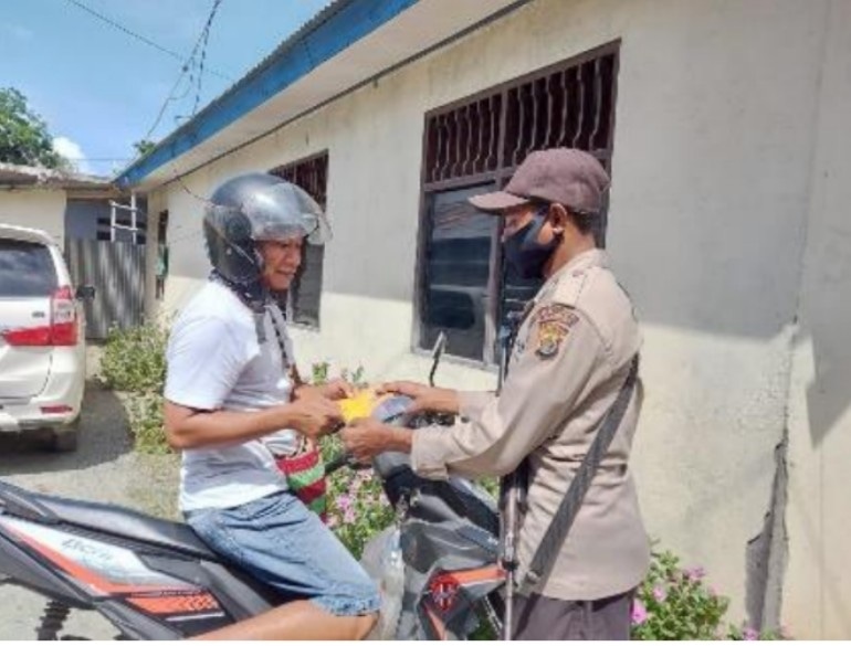 Anggota Polsek Sentani kota  ketika  membagikan masker kepada tukang ojek di Sentani, beberapa waktu lalu.