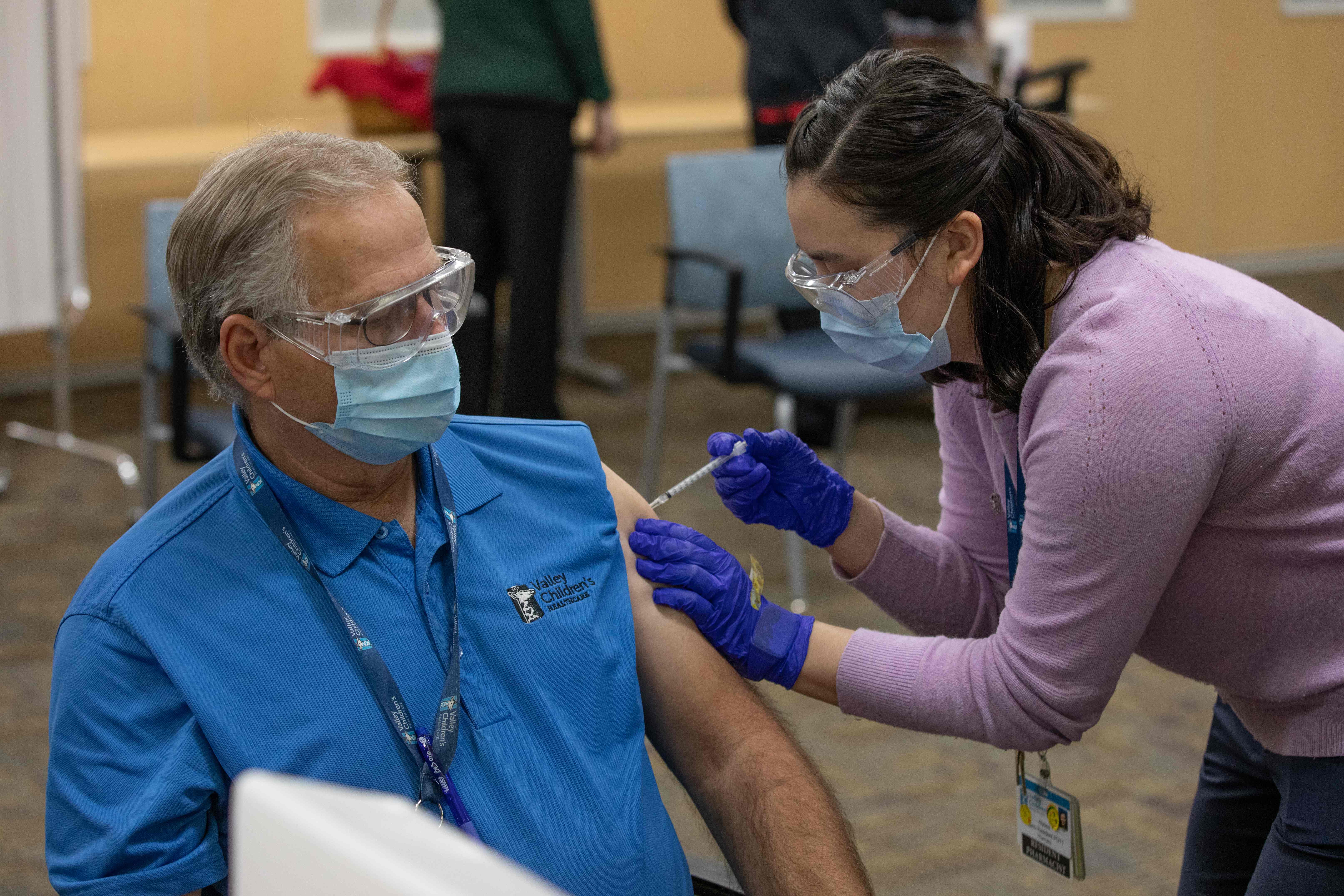 Petugas kesehatan menyuntikkan vaksin covid-19 buatan Pfizer-BionTech kepada nakes di Valley Children’s Hospital in Madera, California.