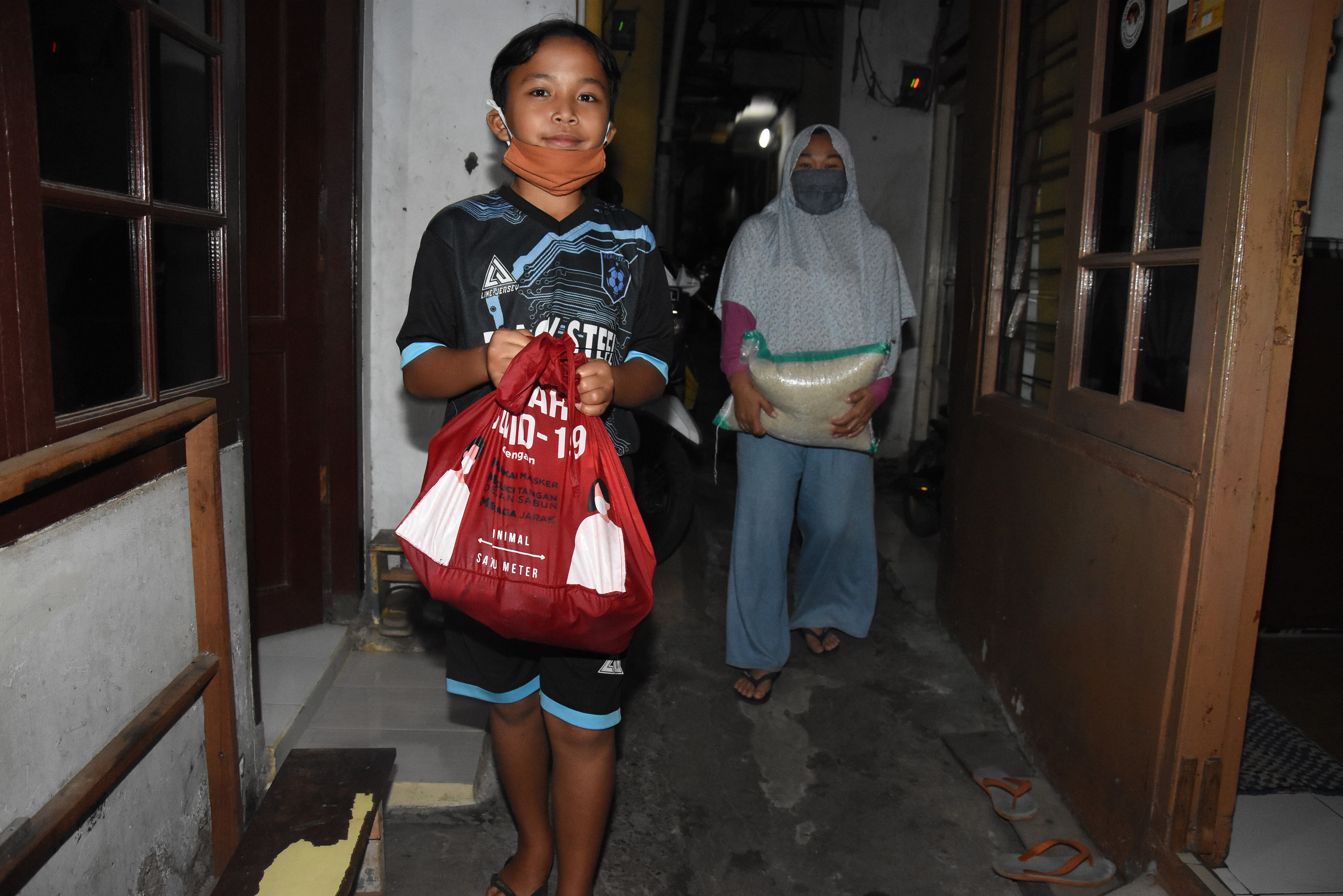 Warga menerima paket bansos di permukiman Jalan Bangka IV, Kelurahan Pela Mampang, Jakarta. Mulai tahun depan, bansos diberikan berupa BLT.