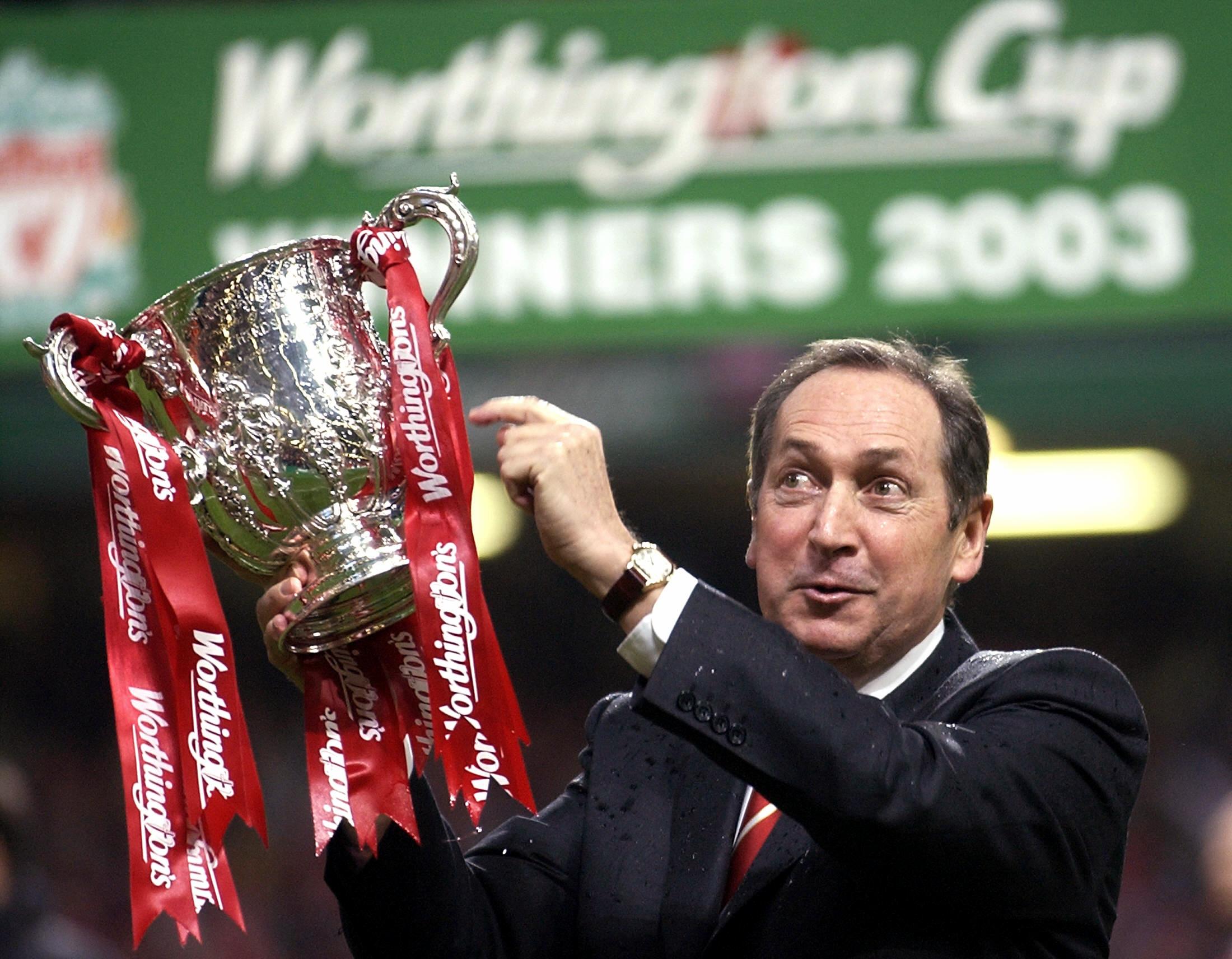 Manajer Liverpool Gerard Houllier mengangkat trofi Piala Liga 2003 usai mengalahkan Manchester United di laga final.