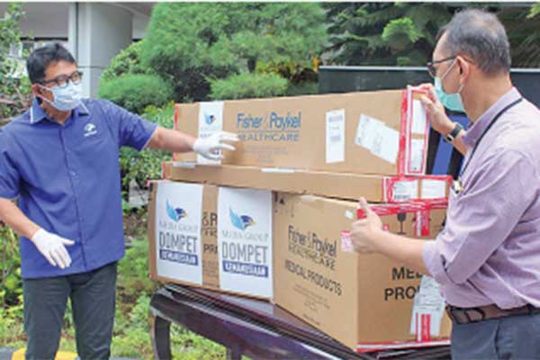 Ketua Yayasan Media Group Ali Sadikin (kiri) menyerahkan bantuan alat terapi oksigen yang diterima dokter spesialis paru Prasenohadi