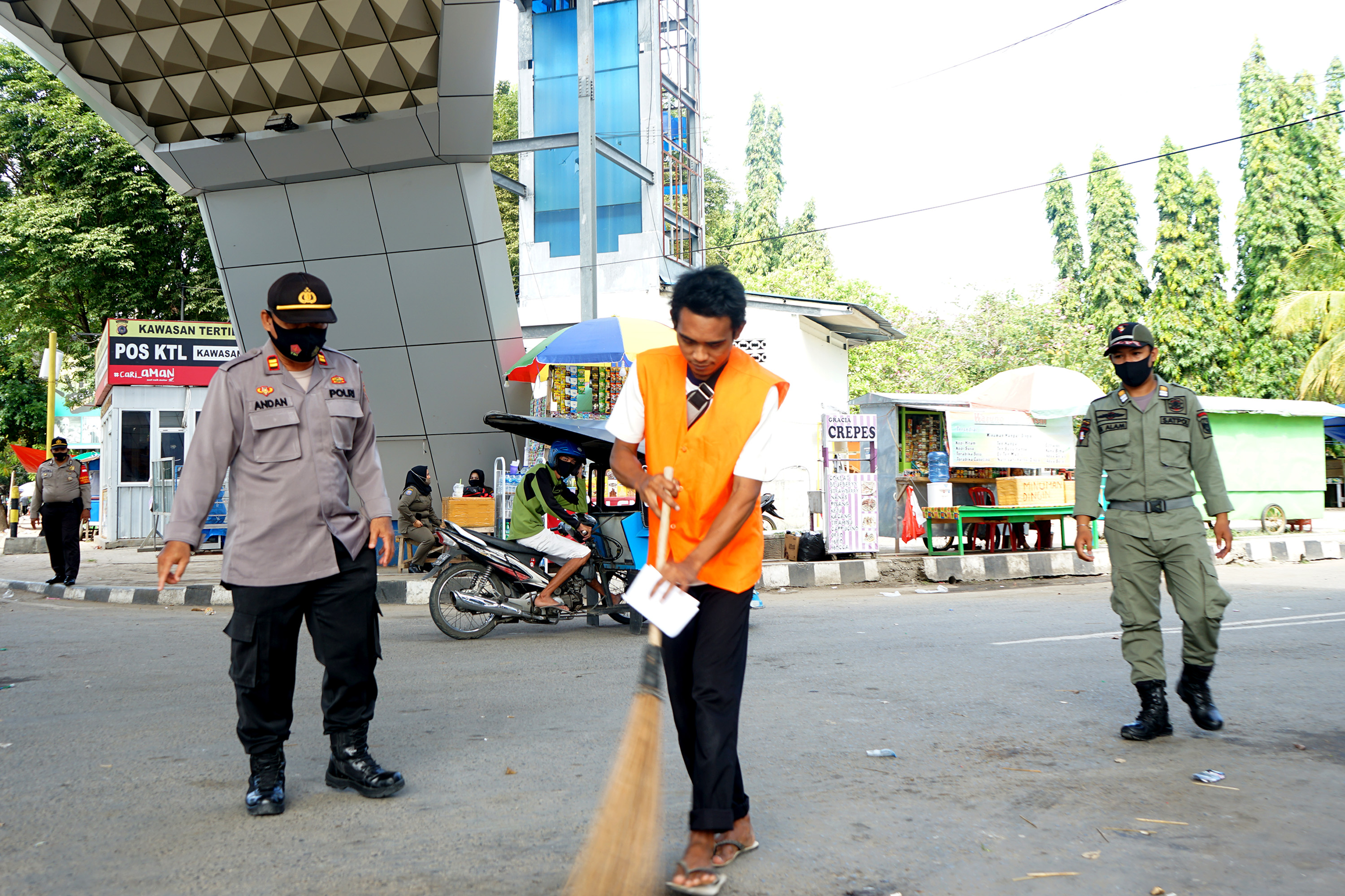 Warga yang tidak memkai masker dikenai sanksi menyapu pada razia protokol kesehatan Operasi Aman Nusa di Limboto, Gorontalo, Rabu (9/12).