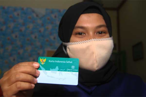 Seorang warga memperlihatkan kartu KIS