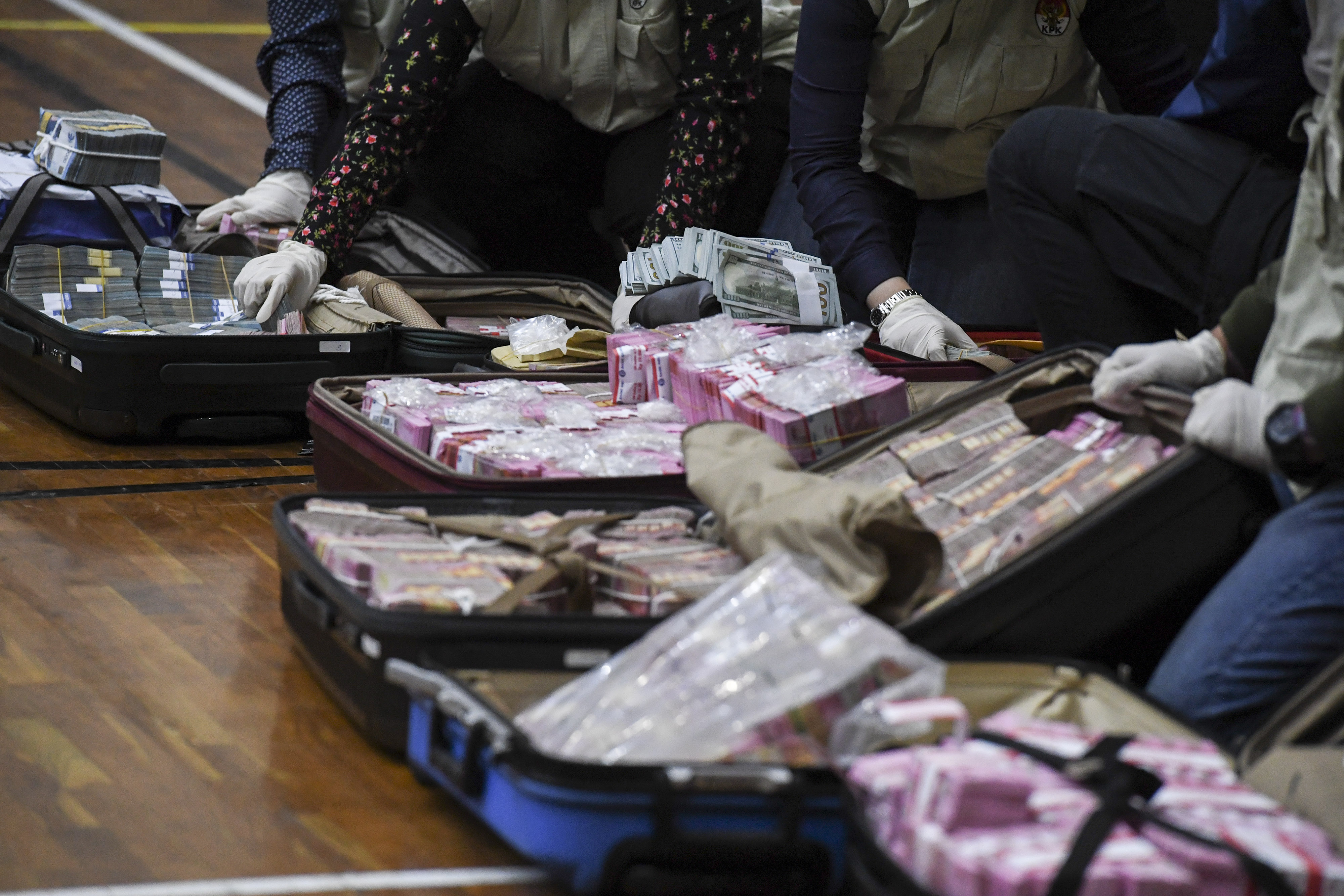 Penyidik KPK menunjukan barang bukti uang tunai dalam kasus dugaan korupsi bansos Covid-19