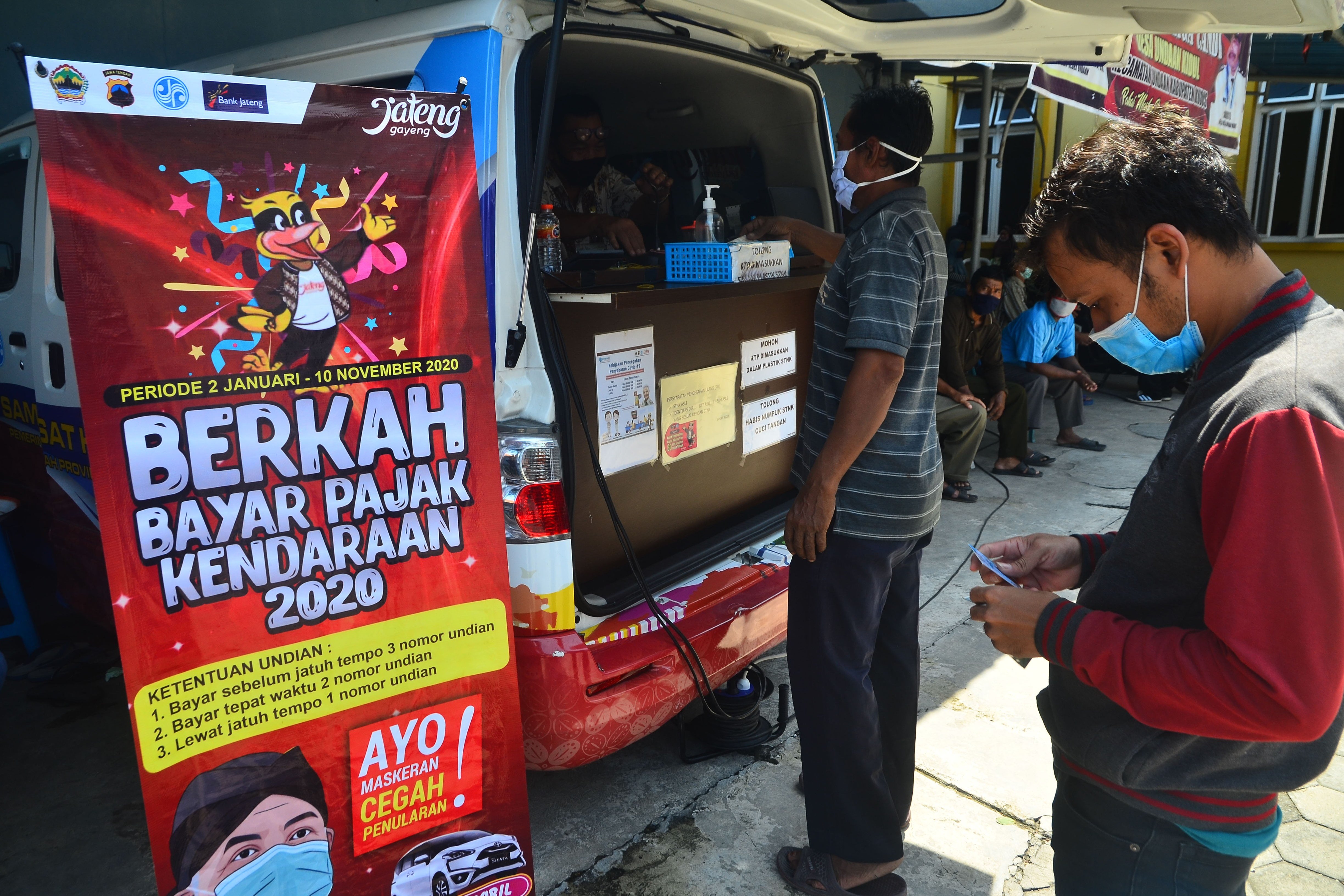 Warga membayar pajak kendaraan bermotor di Mobil Samsat Keliling di Desa Undaan Kidul, Kudus, Jawa Tengah, Rabu (11/11)..