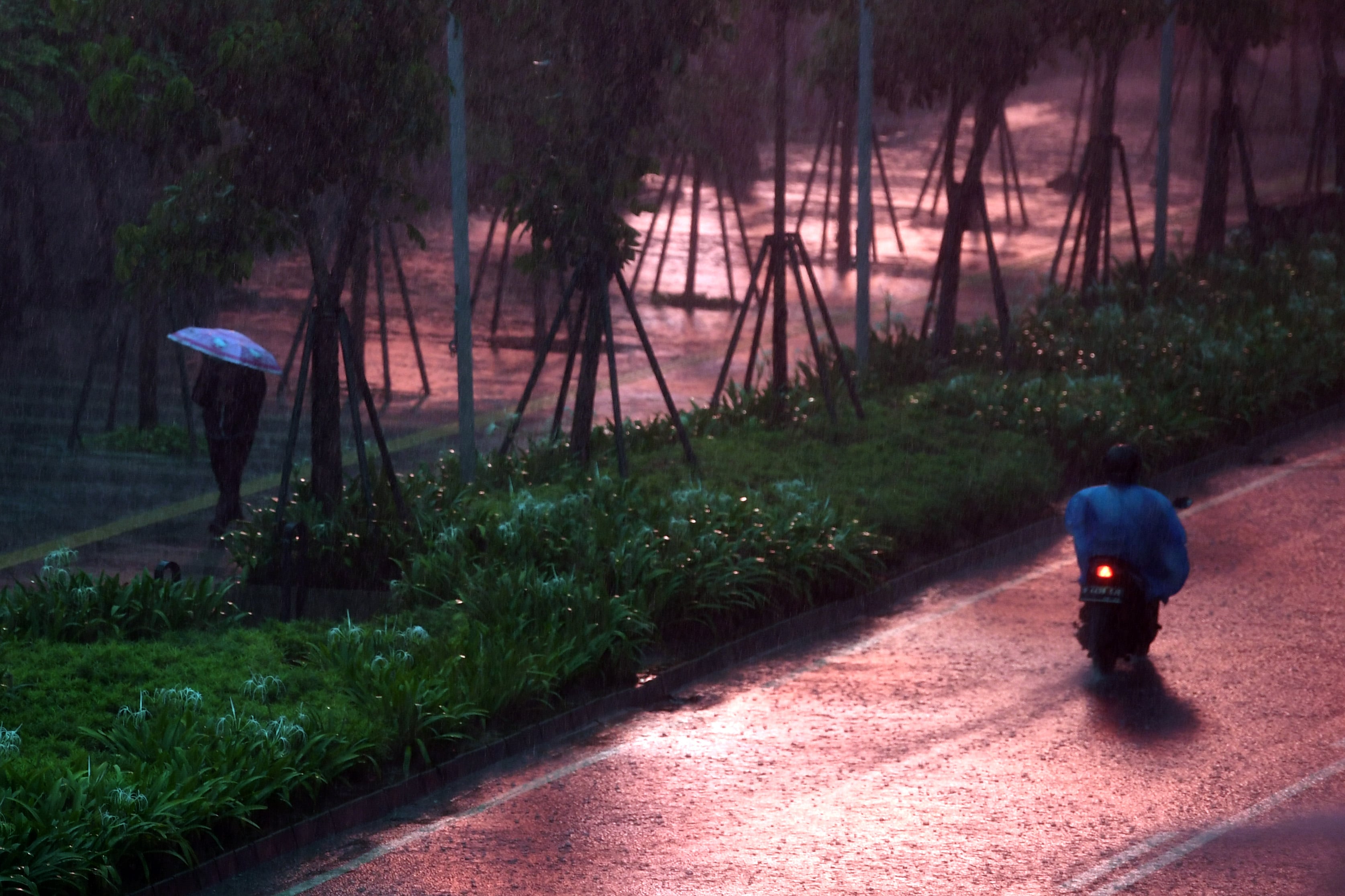  Seorang warga membawa payung saat melintas di Kawasan Senayan, Jakarta, Jumat (16/10)