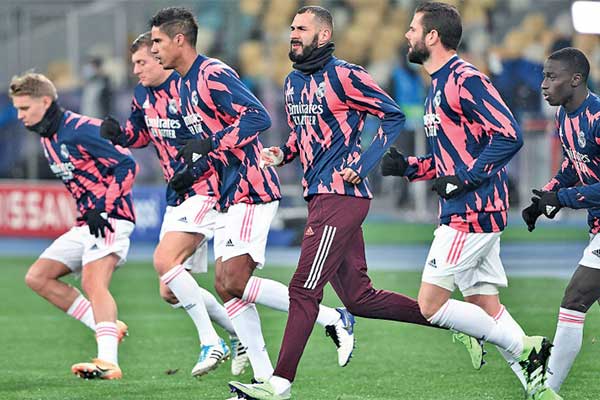 Striker Real Madrid Karim Benzema melakukan pemanasan bersama rekan-rekannya