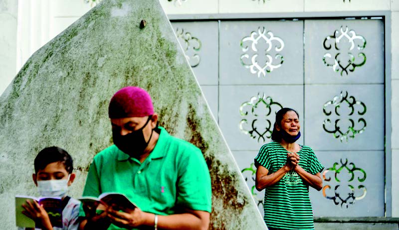 BERDOA: Warga mengaji dan berdoa saat berziarah di kuburan masal Tsunami, di Desa Ulee Lheue, Banda Aceh, Aceh, kemarin