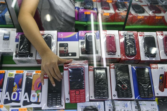 Pedagang mengambil salah satu ponsel di salah satu gerai di Jakarta, Kamis (20/8).  