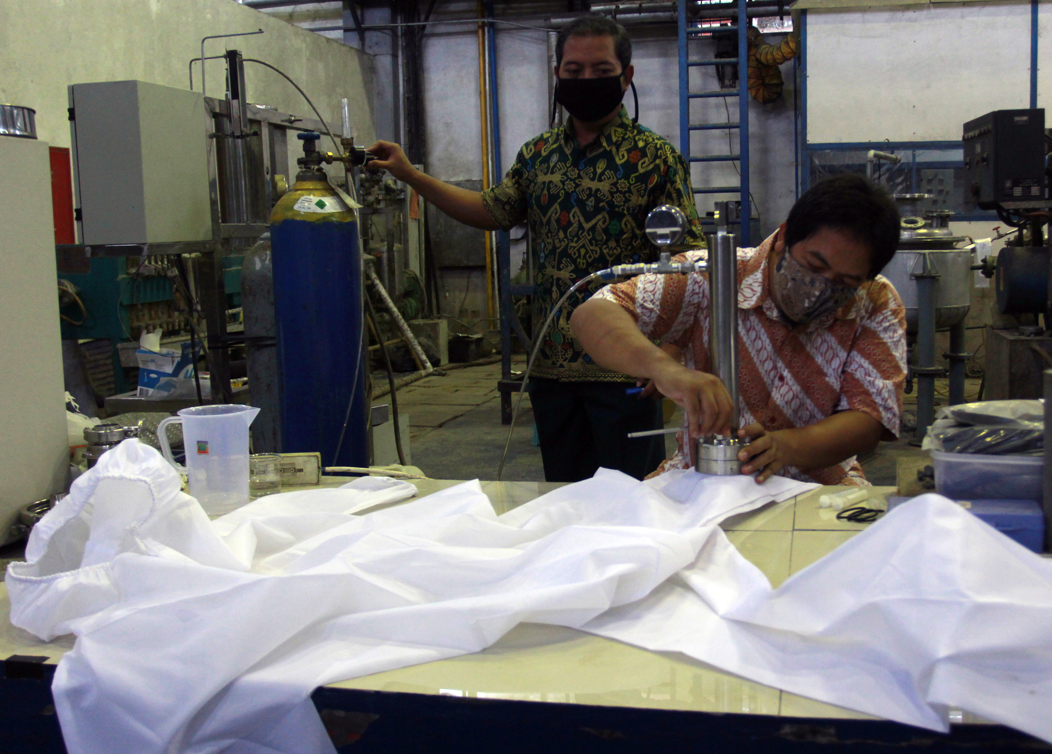 Peneliti LIPI menguji tekanan air ke hazmat yang sudah dilapisi nano partikel perak antimikroba di Lab Kimia LIPI, Serpong, Jumat (20/11).