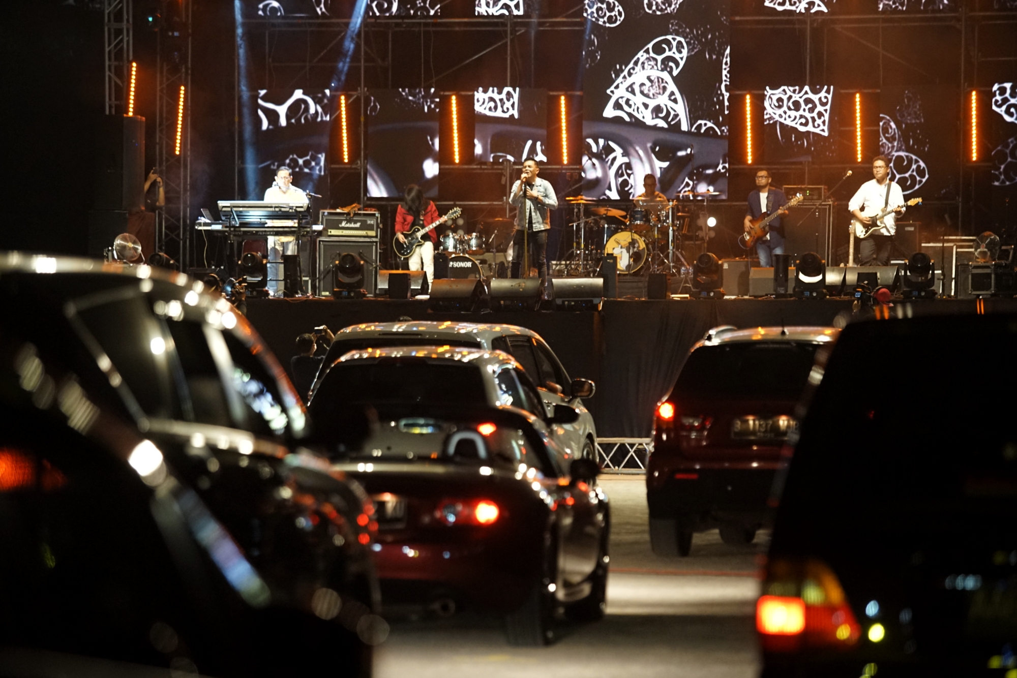  Penonton menyaksikan penampilan band Jikustik dari dalam mobil saat konser musik drive-in di Sleman City Hall,  Yogyakarta.
