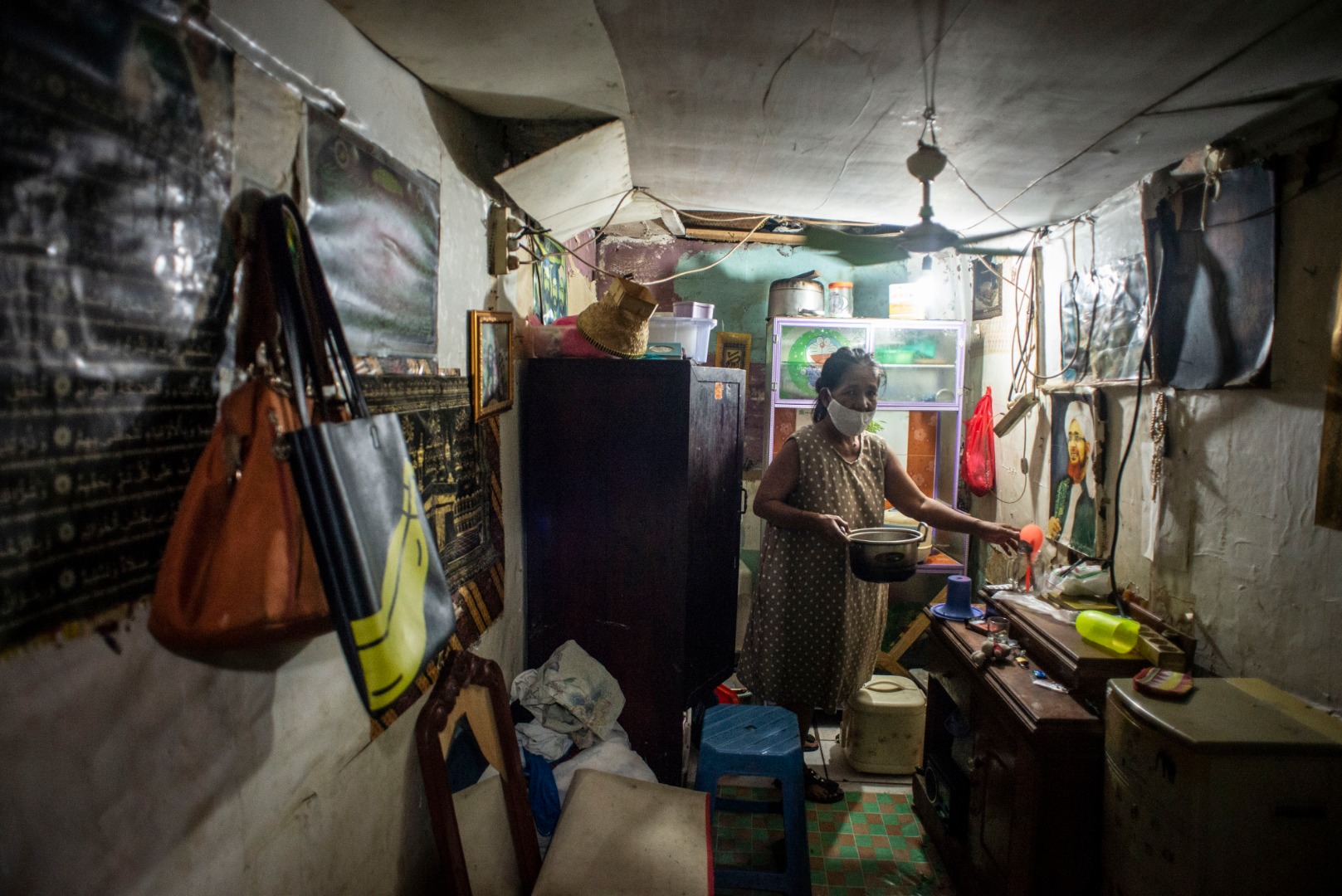 Seorang warga mengemas barang miliknya saat petugas PPSU menertibkan hunian liar di kolong jembatan