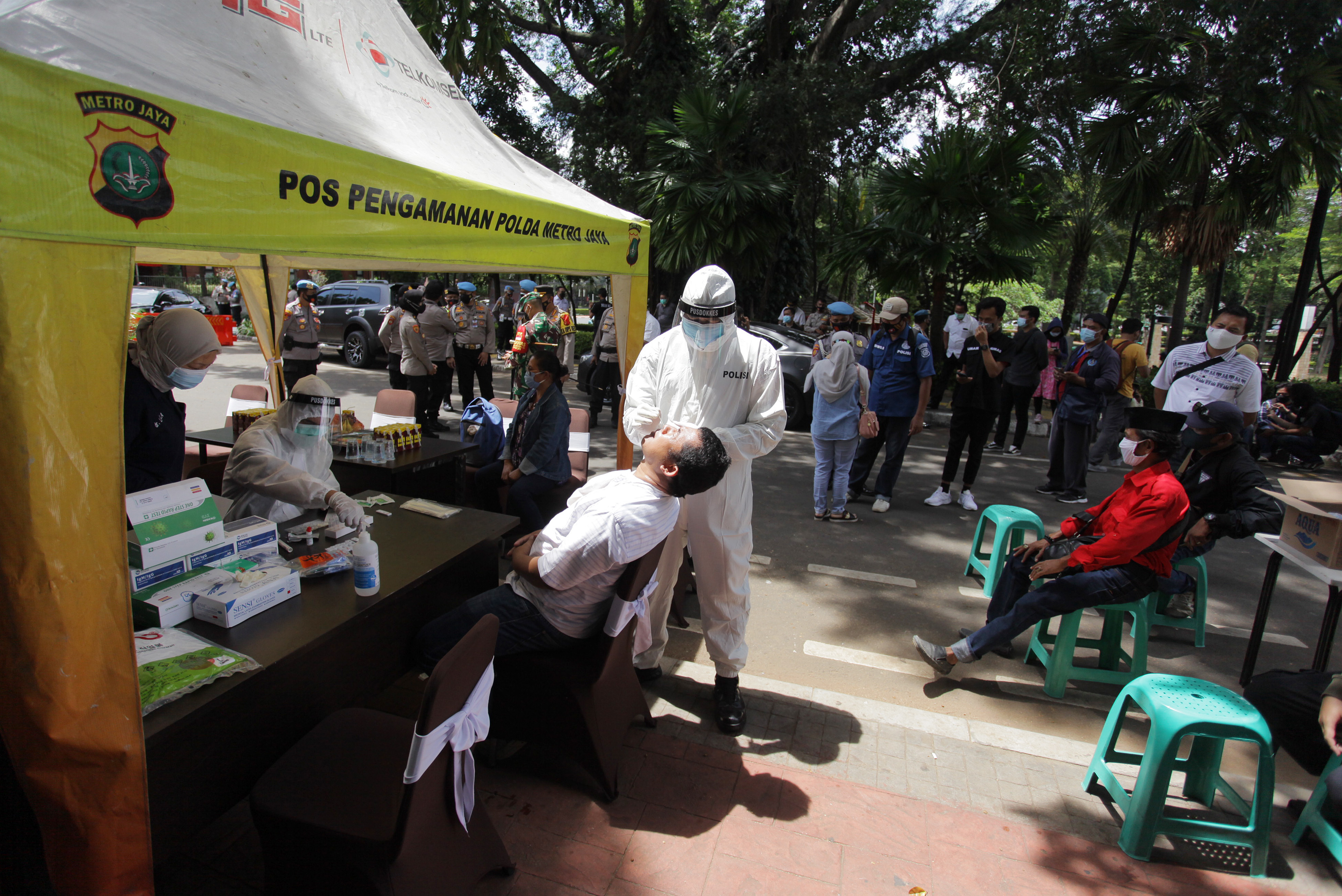 Petugas kesehatan mengambil sampel usap warga saat mengikuti rapid test antigen gratis di kawasan Melawai Raya, Jakarta.