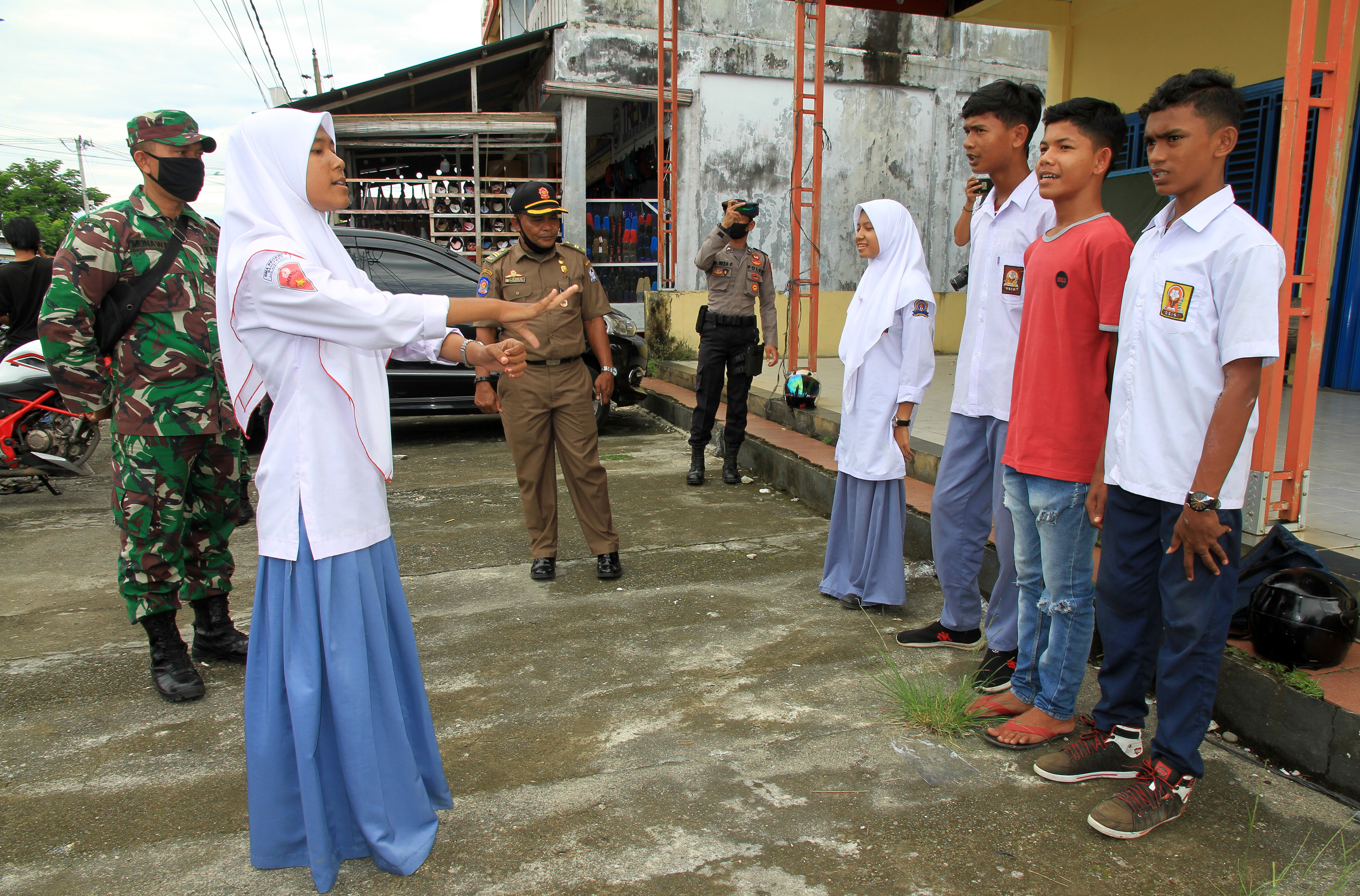 Sejumlah pelajar menyanyikan lagu Indonesia Raya saat terjaring razia protokol kesehatan di Desa Gampa, Kecamatan Johan Pahlawan, Aceh.