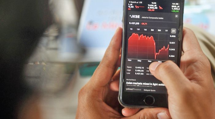 Investor memantau perdagangan saham melalui gawainya di Jakarta. 