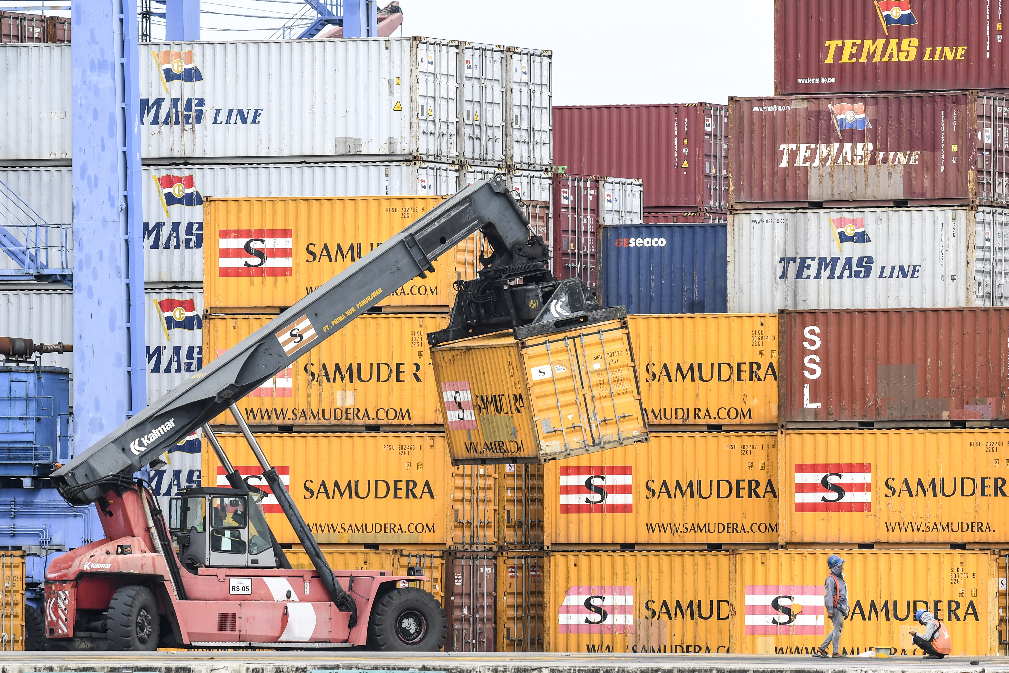 Ilustrasi pekerja yang melakukan bongkar muat peti kemas di pelabuhan.