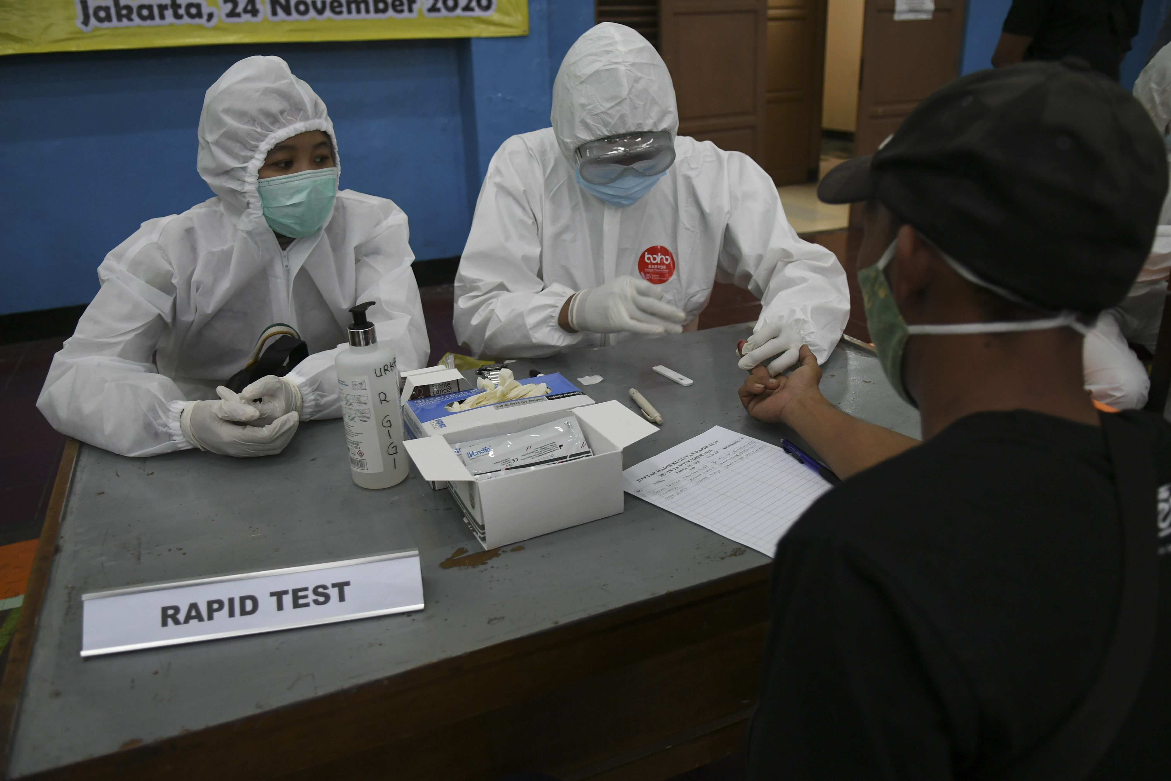 Tenaga medis melakukan tes cepat (rapid test) COVID-19 terhadap warga di Gelanggang Olahraga Tebet, Jakarta.