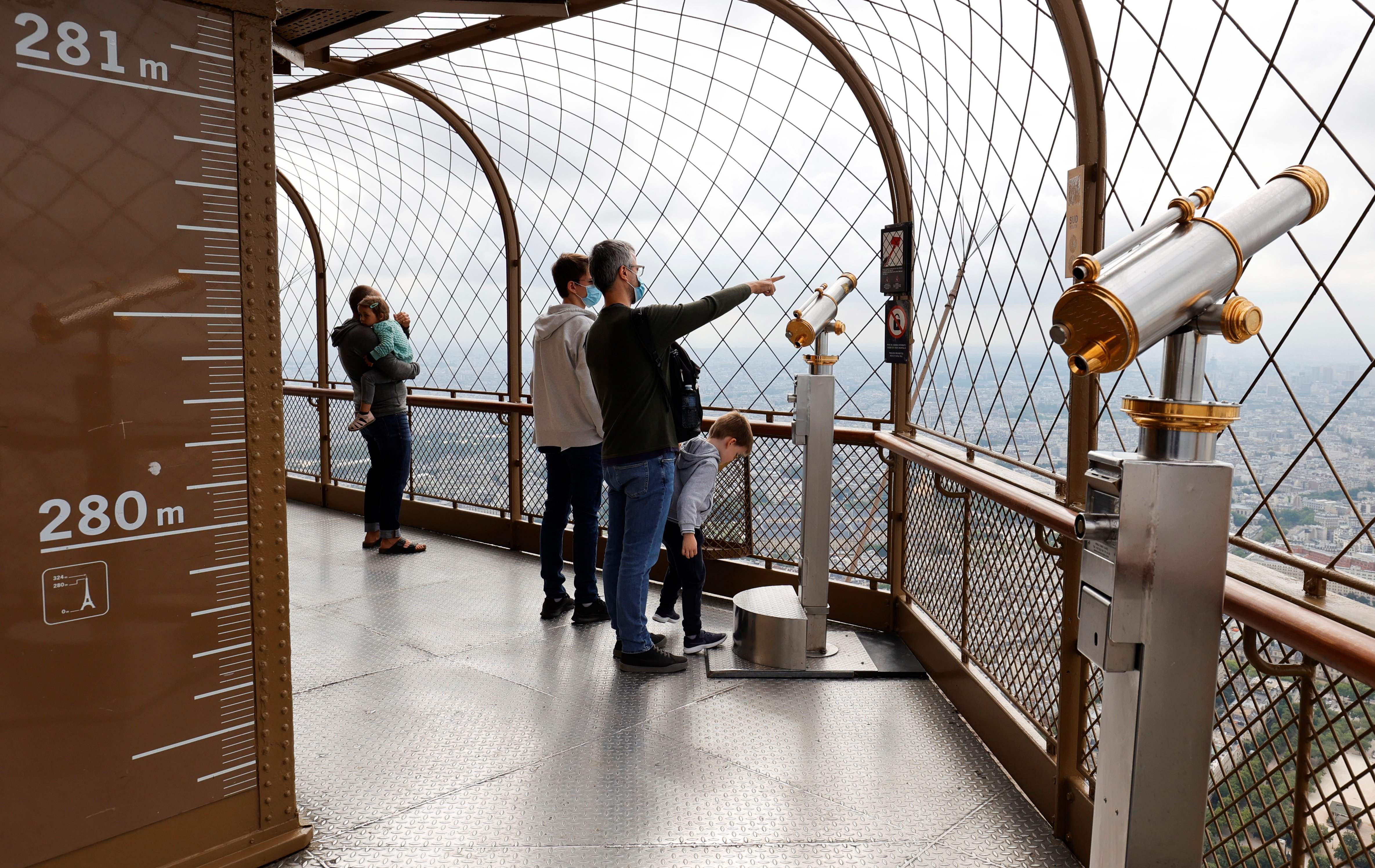 Warga mengenakan masker saat berada di atas Menara Eifel di Paris, Prancis.