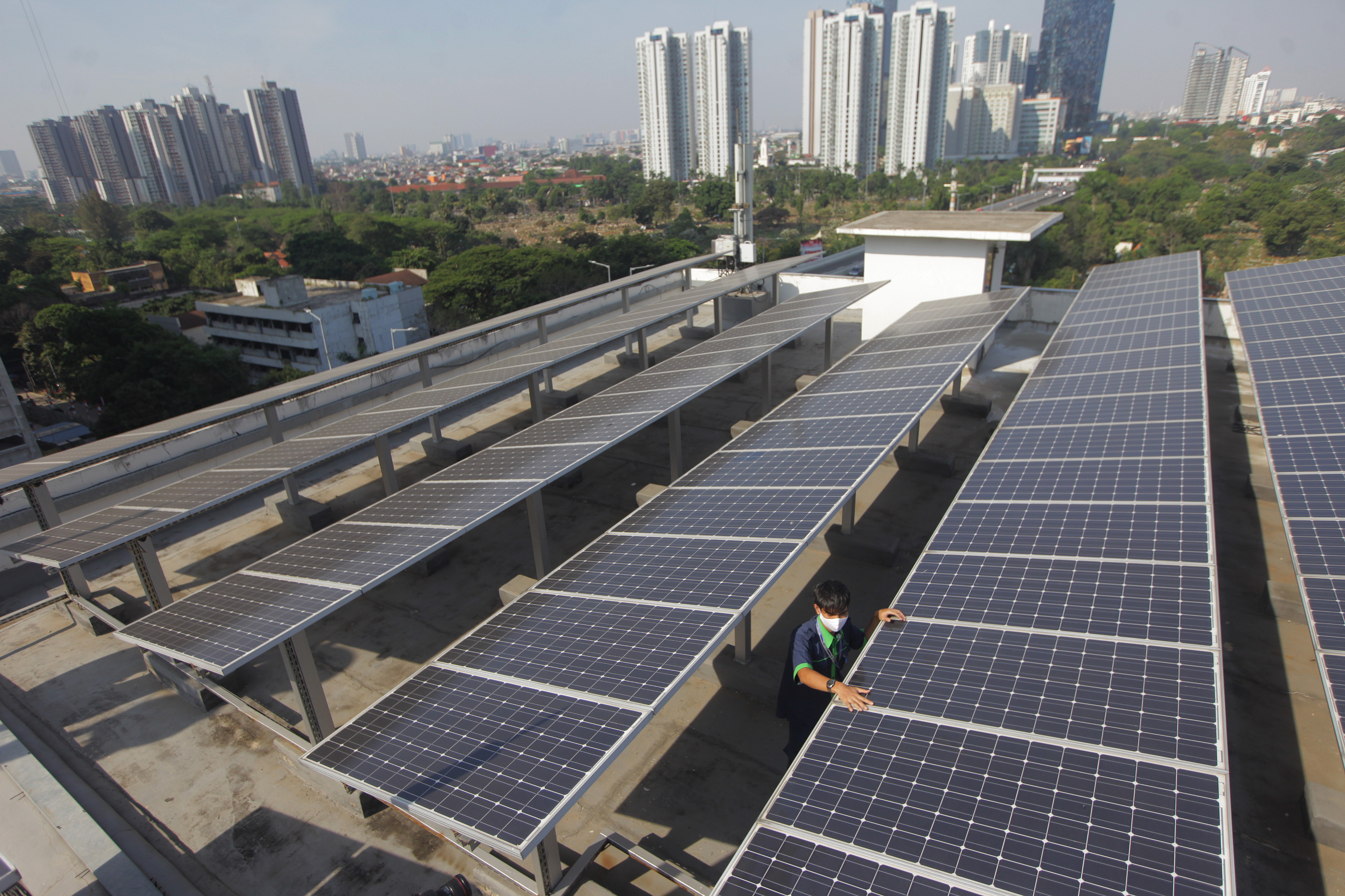 Pekerja tengah mengecek panel surya di atas gedung, di Jakarta, Senin (31/8/2020). 