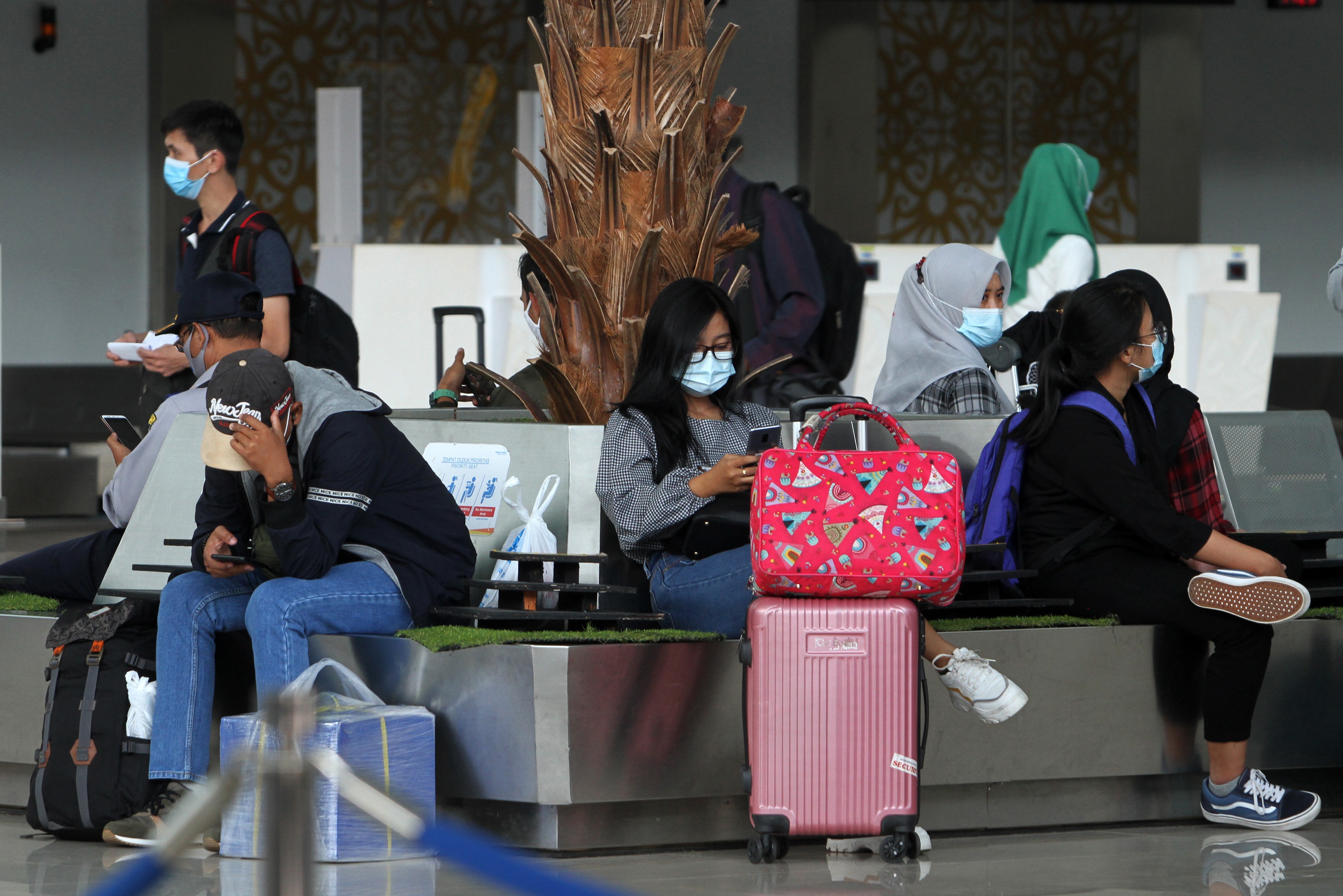 Sejumlah calon penumpang pesawat duduk di terminal keberangkatan Bandara Supadio, Kabupaten Kubu Raya, Kalimantan Barat, Kamis (24/12).