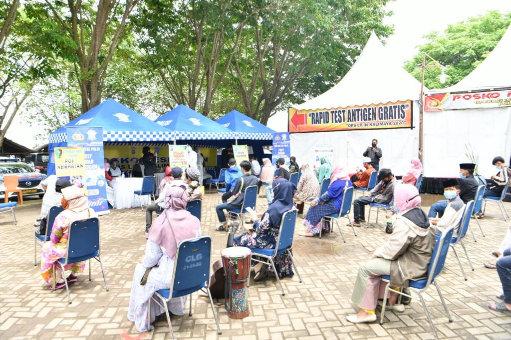 Wisatawan mengantri rapid antigen gratis di wisata Mercusuar Cikoneng, Anyer, Banten yang diadakan Korlantas dan Kompolnas, Rabu (30/12)